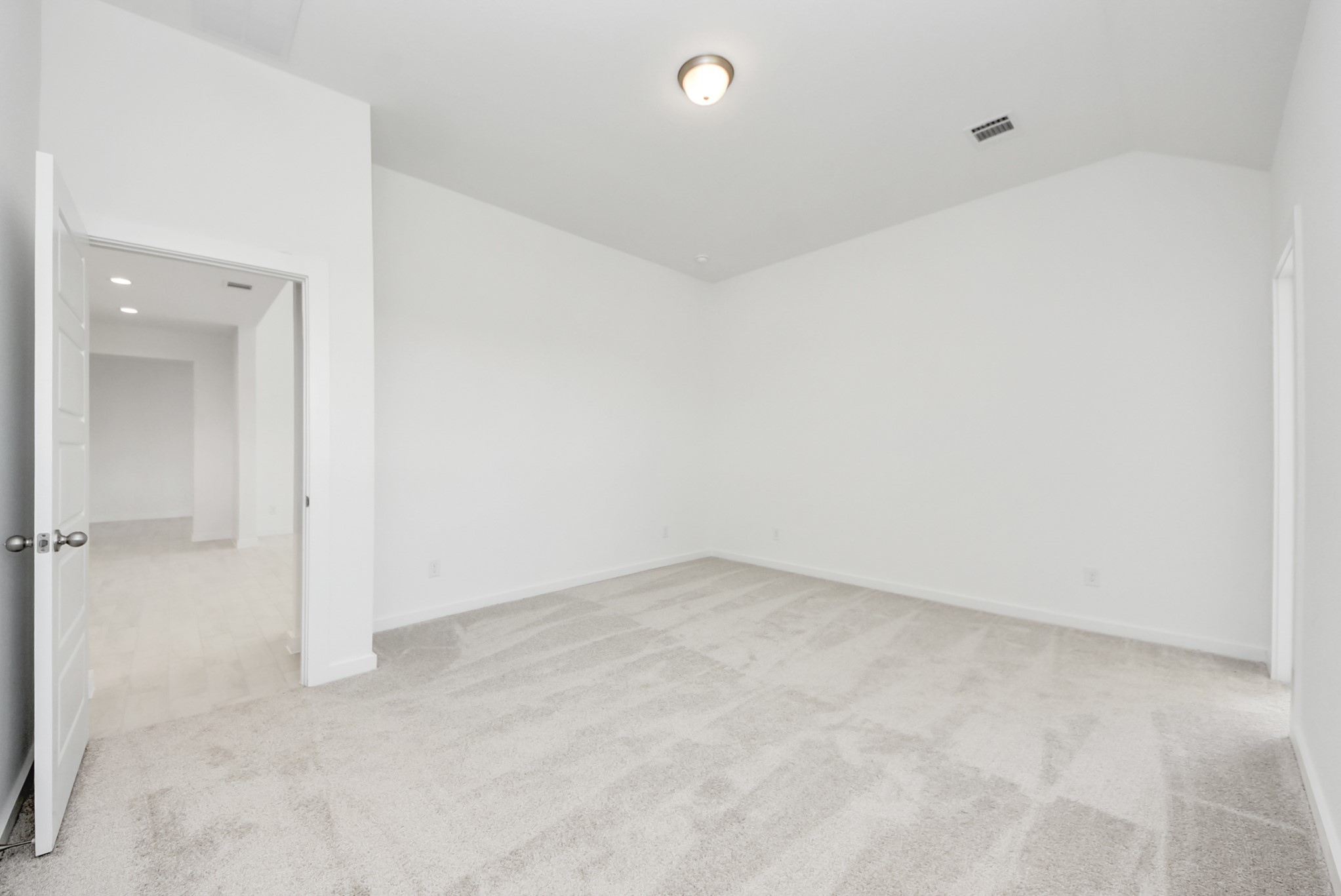 Escape and relax in the exquisite primary suite, a haven to unwind after a long day. The spacious room, located on first floor, boasts plush carpeting, soothing paint tones, high ceilings, and expansive windows adorned with privacy blinds.