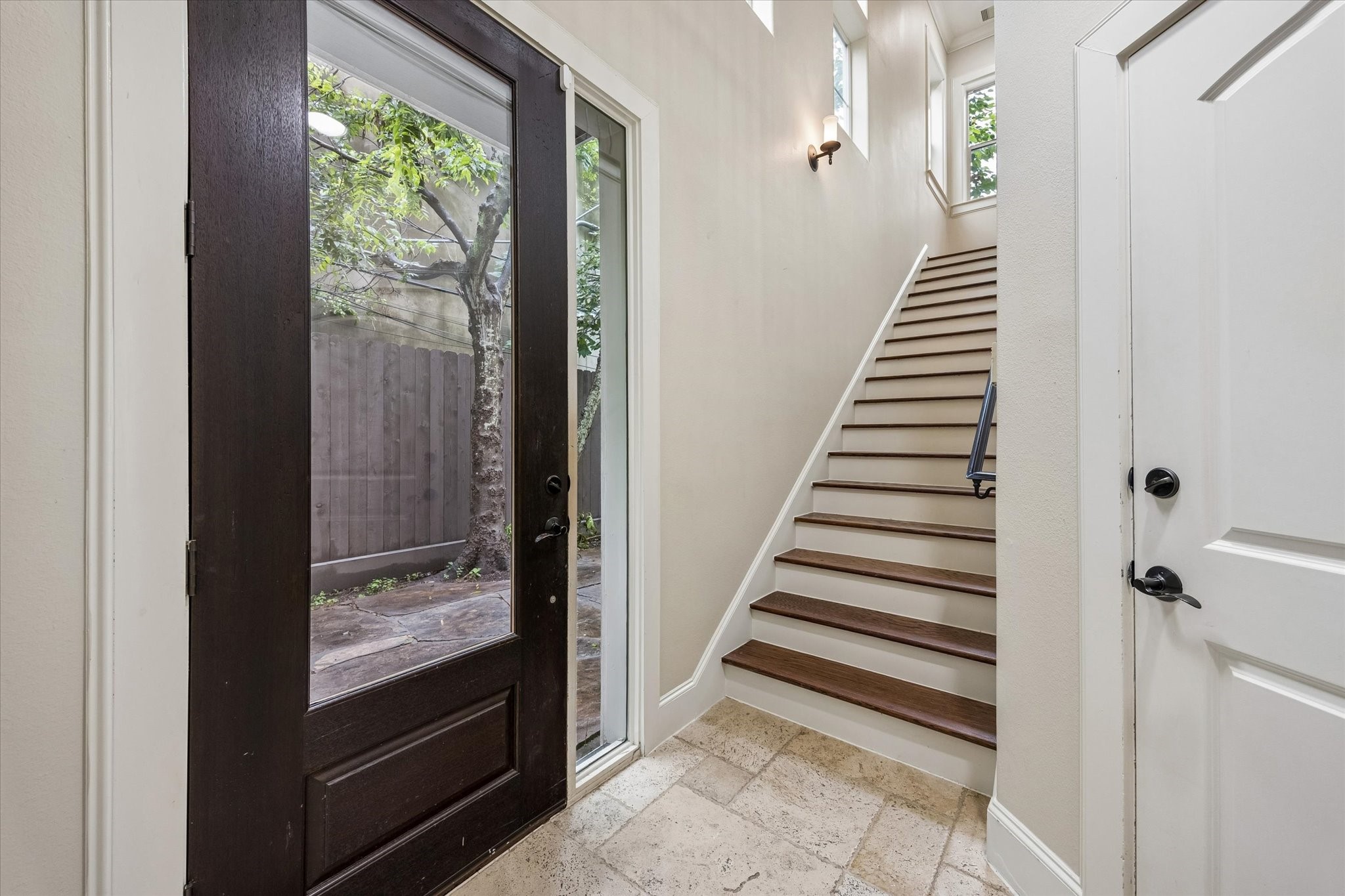 The front door opens to stairs, garage access, and the first-floor bedroom. The front door opens to stairs, garage access, and the first-floor bedroom.