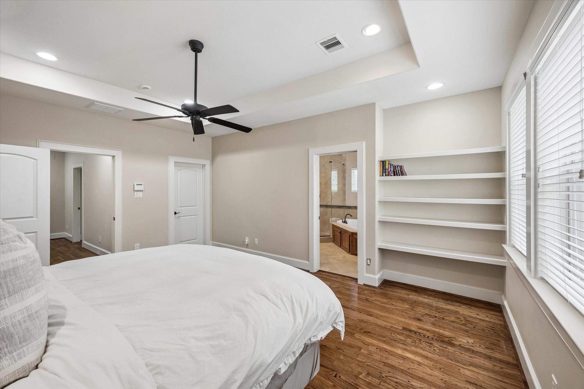Another view of the primary bedroom, looking toward the bathroom on the right and hallway on the left.