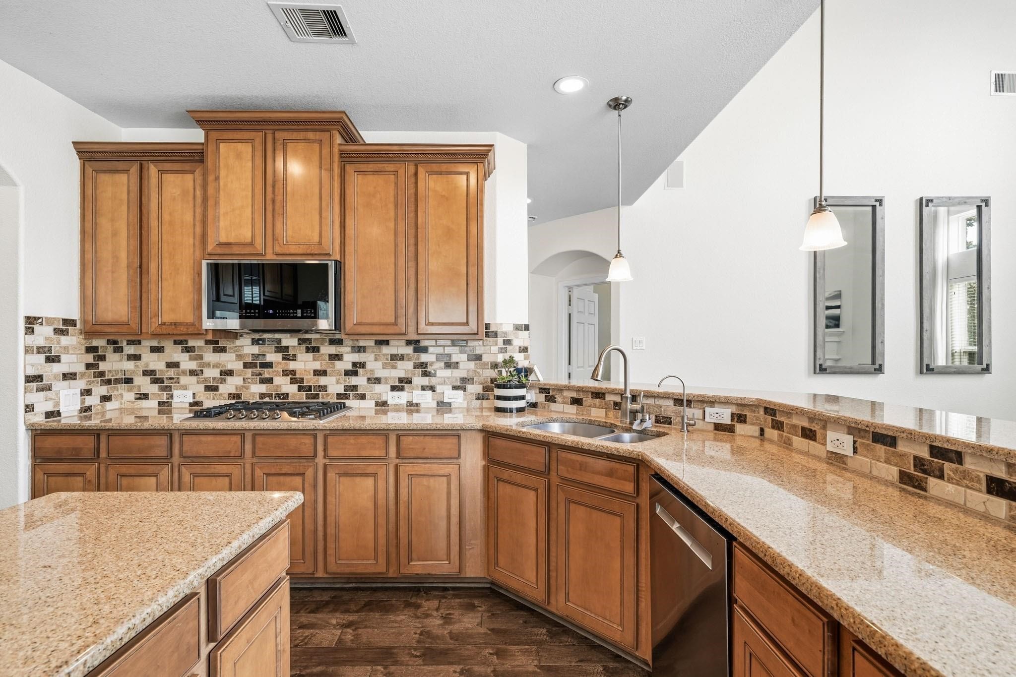 A perfect blend of beauty and practicality, this kitchen features granite countertops with decorative tile back splash that elevates the entire space along with plenty of storage space.