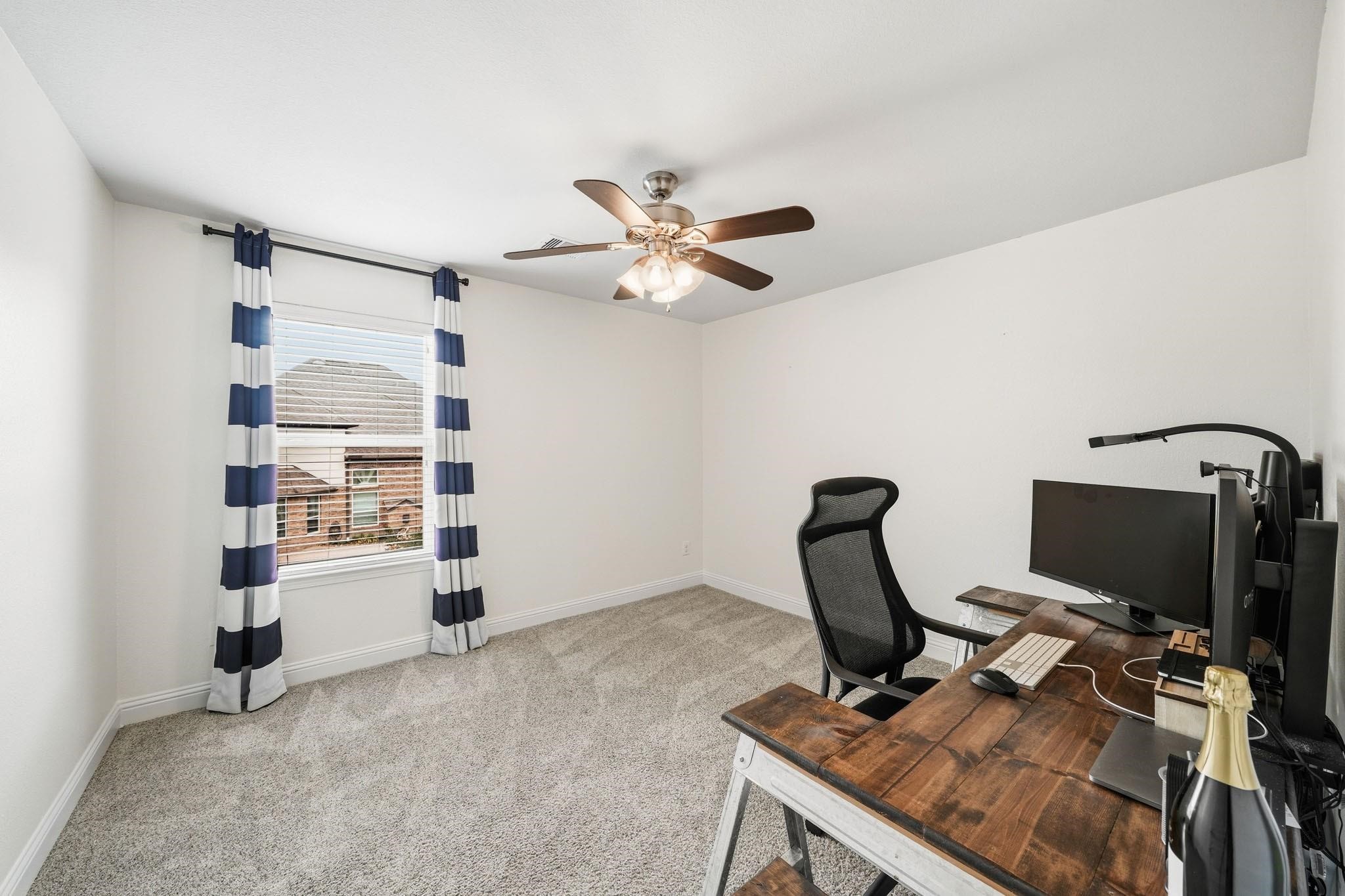 Tucked discreetly beyond the fourth bedroom closet, this versatile bonus room feels like a private sanctuary, complete with soft carpet, a sunlit window, and a ceiling fan for year-round comfort.