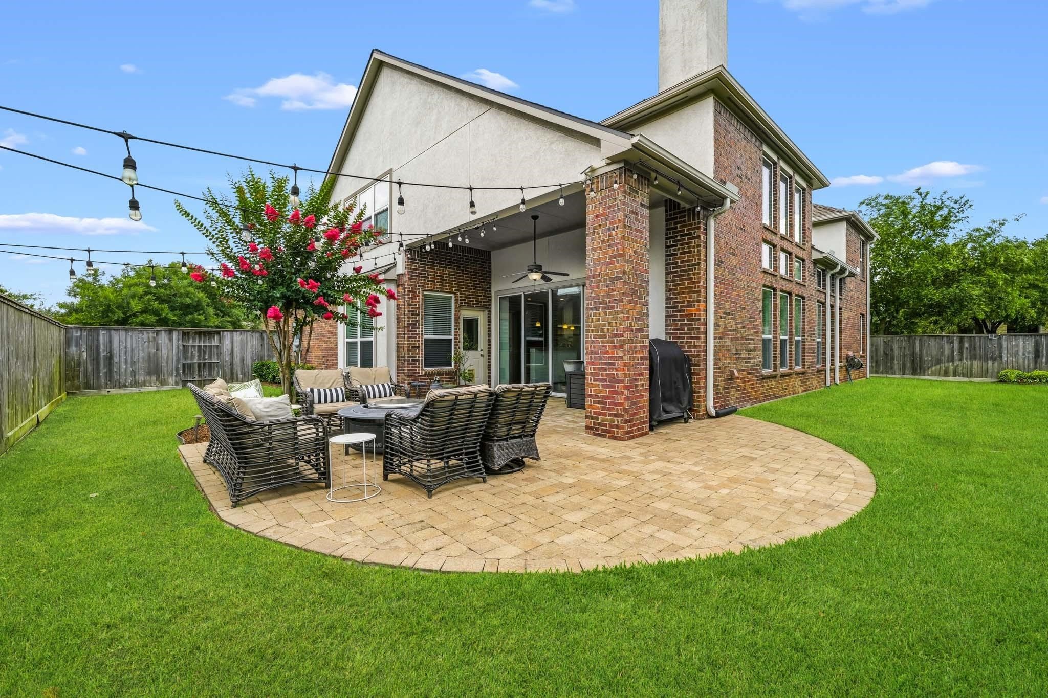 Framed by elegant brick columns and enhanced by tall ceilings, this covered patio offers a comfortable and sophisticated setting for morning coffee, evening gatherings, and everything in between.