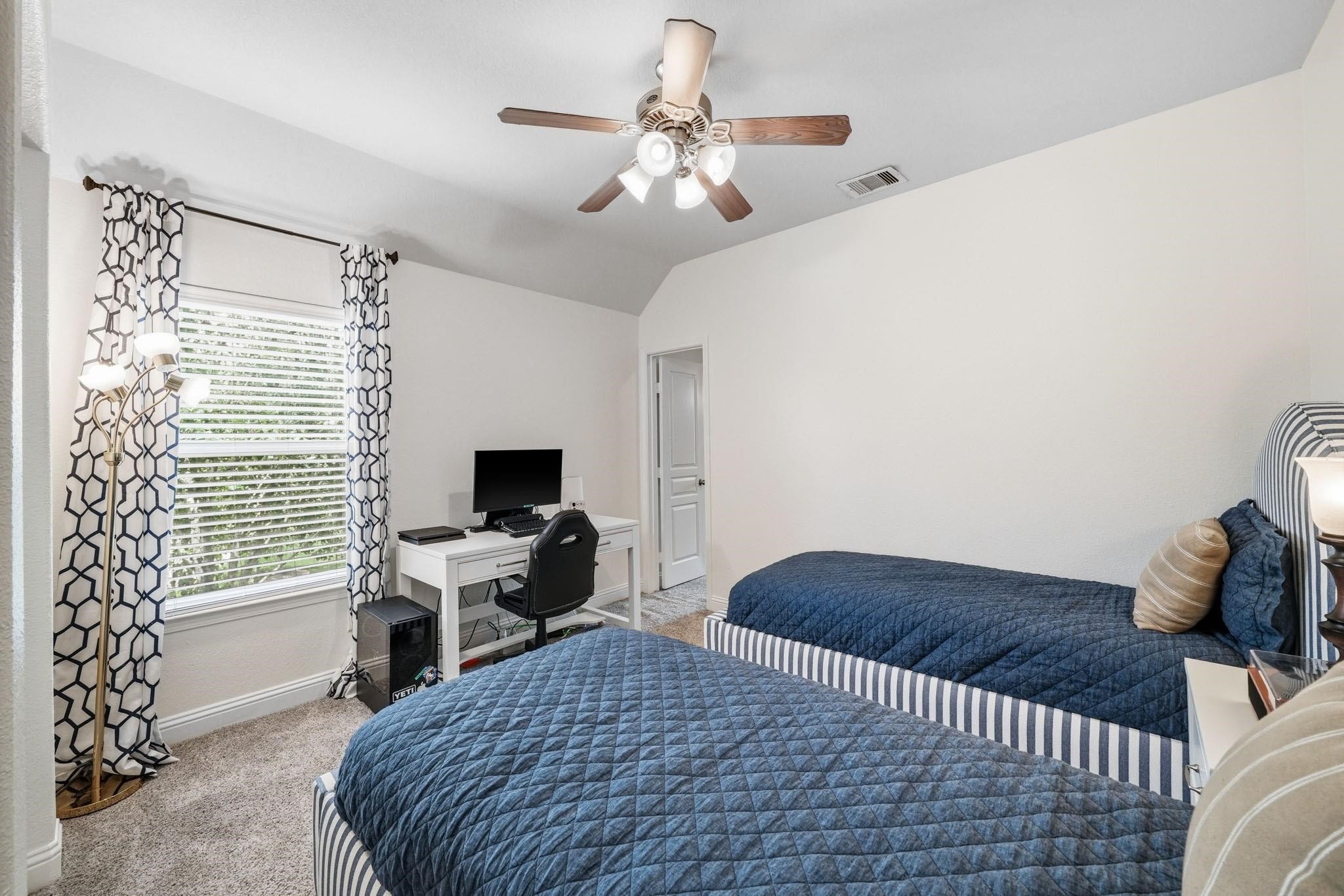 Wrapped in comfort and style, the fourth bedroom features a tray ceiling, plush carpeting, and a ceiling fan with integrated light, making it an ideal spot. Through the door on the right is a walk-in closet woth access to a bonus/flex room.