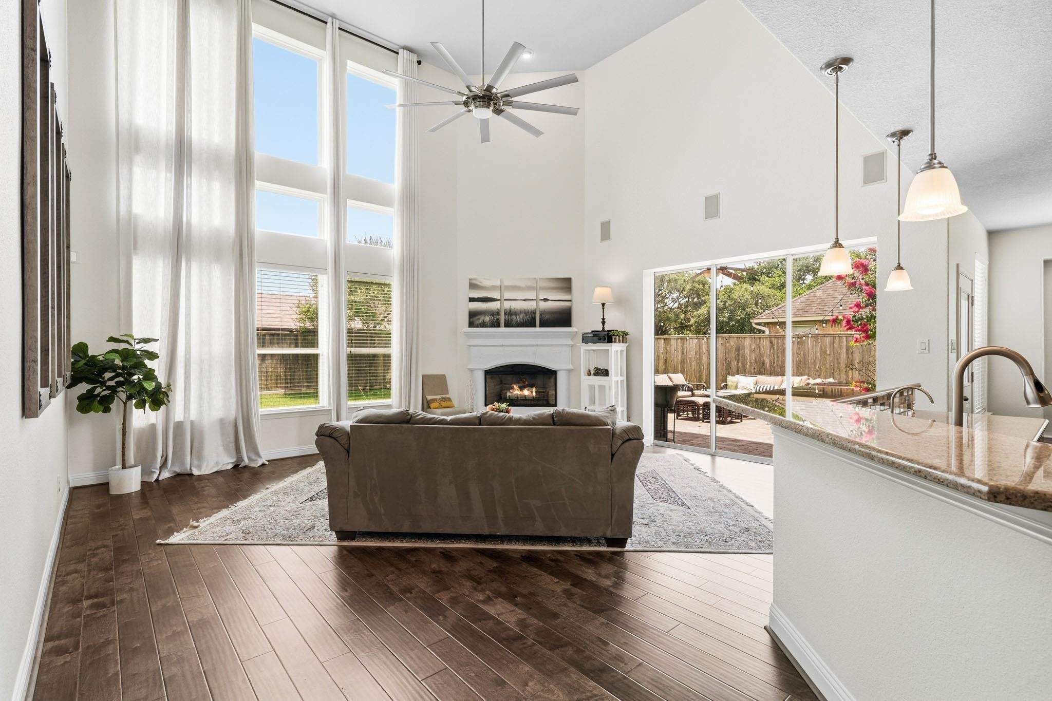 Soaring two-story ceilings, rich hardwood floors and a dramatic wall of windows dressed with blinds and drapes create a stunning gathering space filled with natural light. Soaring two-story ceilings, rich hardwood floors and a dramatic wall of windows dressed with blinds and drapes create a stunning gathering space filled with natural light.