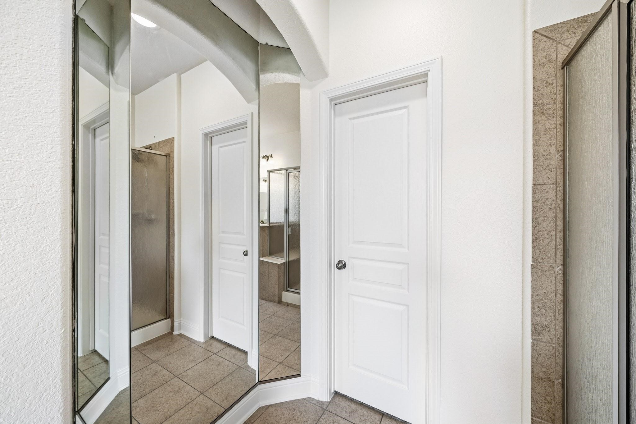 Full-length mirrors enhance the sense of space and light, adding an elegant touch to the primary bath.