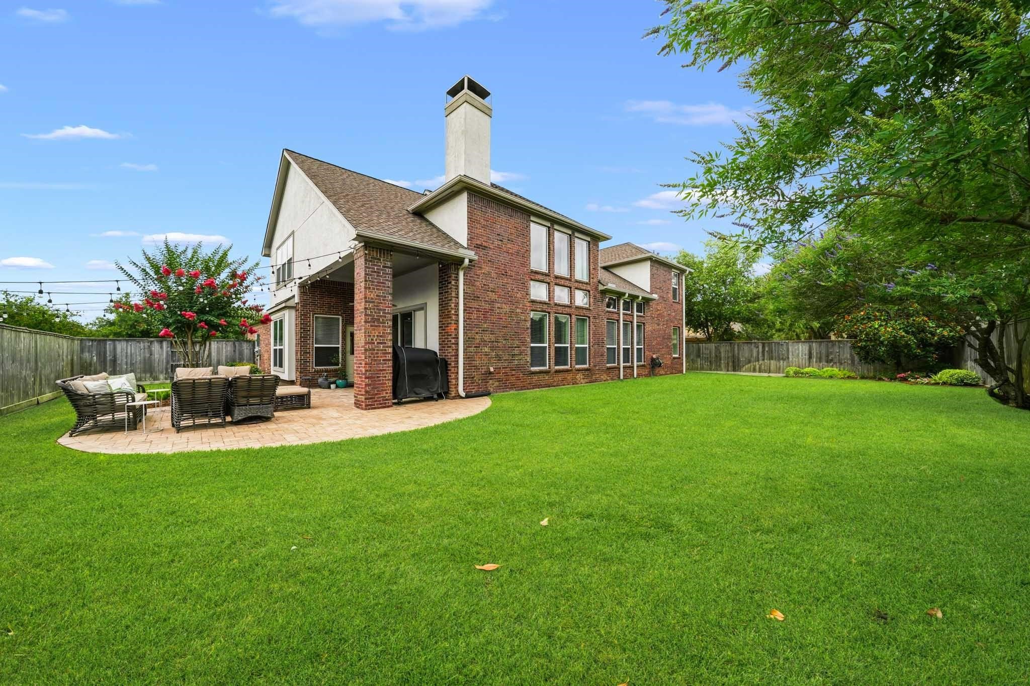 Vibrant landscaping, mature trees, and expansive green space transform the backyard into a secluded space where beauty, privacy and Texas outdoor living come together effortlessly.