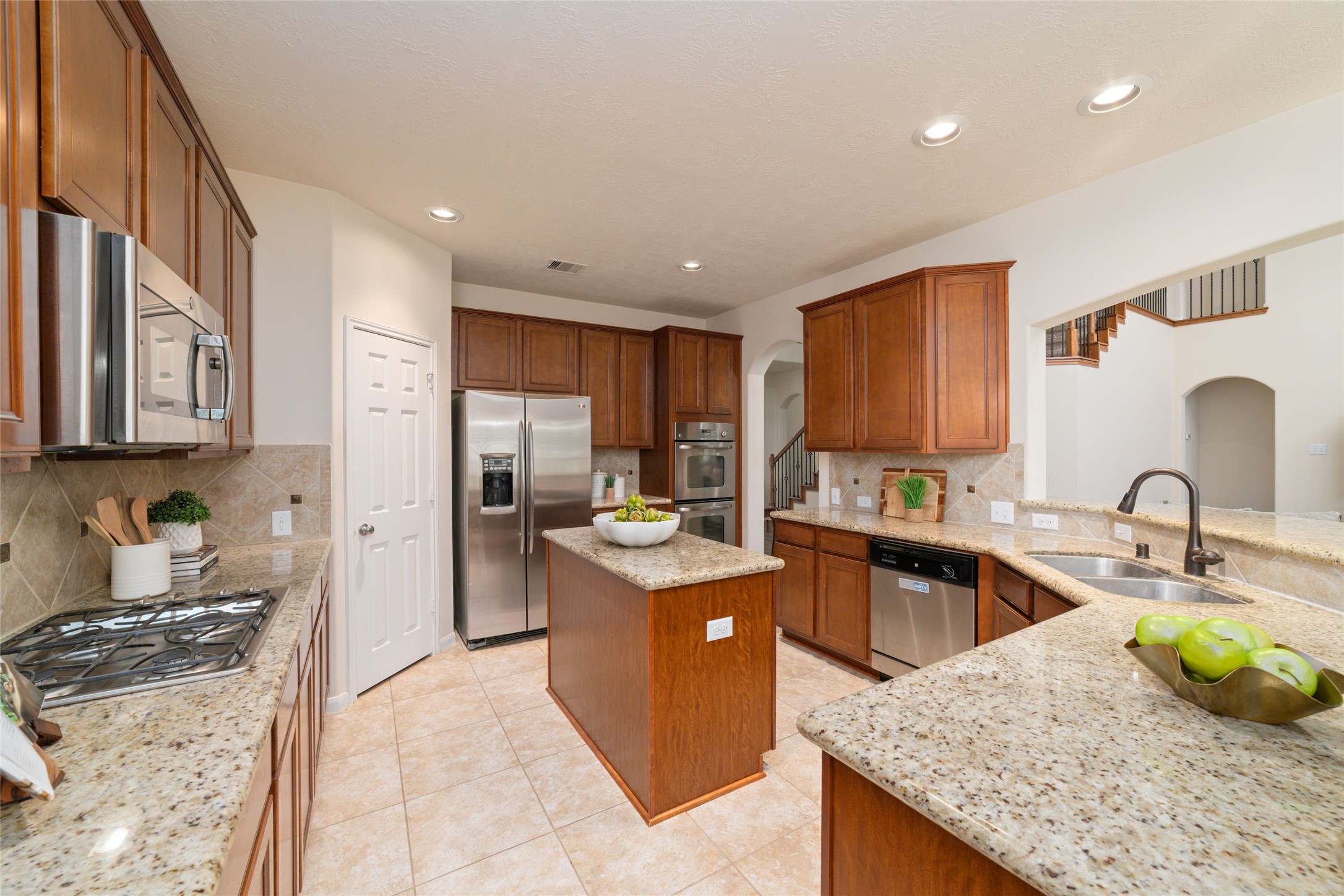 Chef's kitchen with gas cooktop, double ovens, island and plenty of counters and cabinets for seamless cooking and entertaining