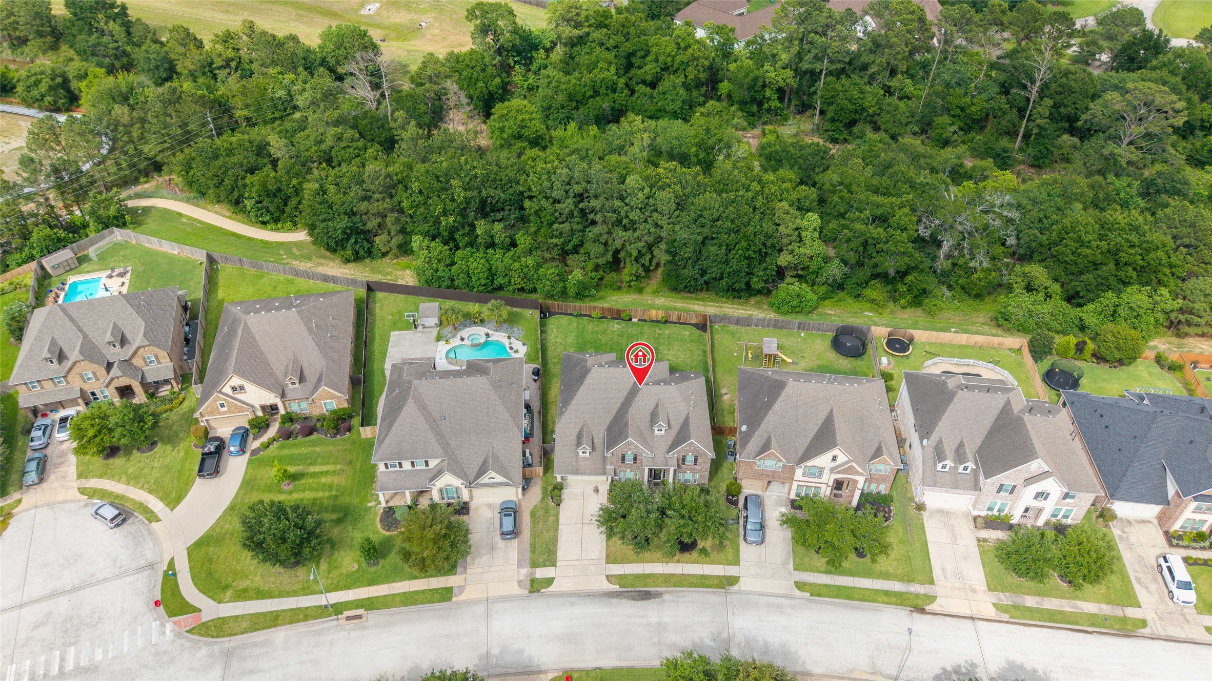 Aerial view highlighting the wooded area and walking trails.