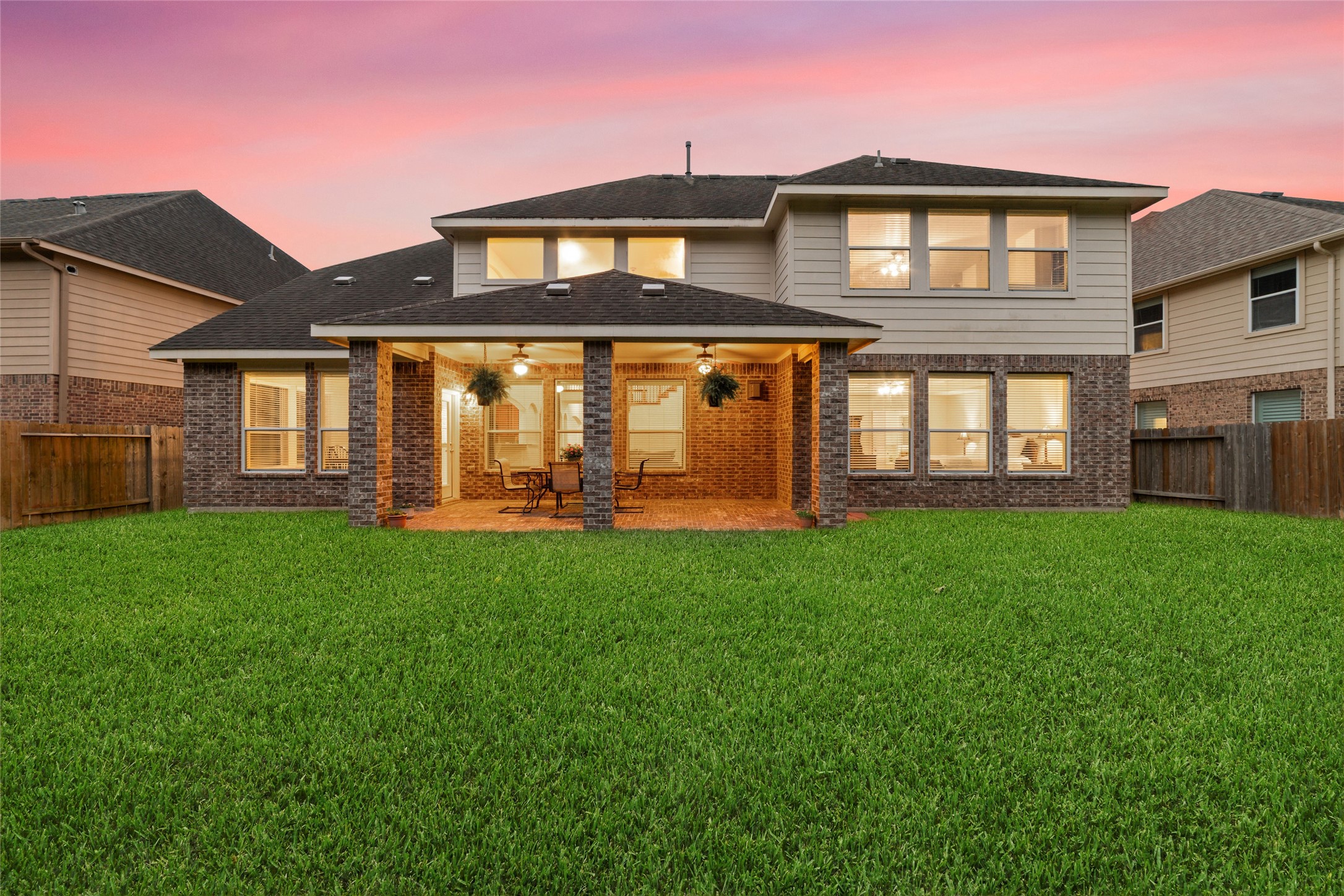 View of the large covered patio and wall of windows on the rear of the home.