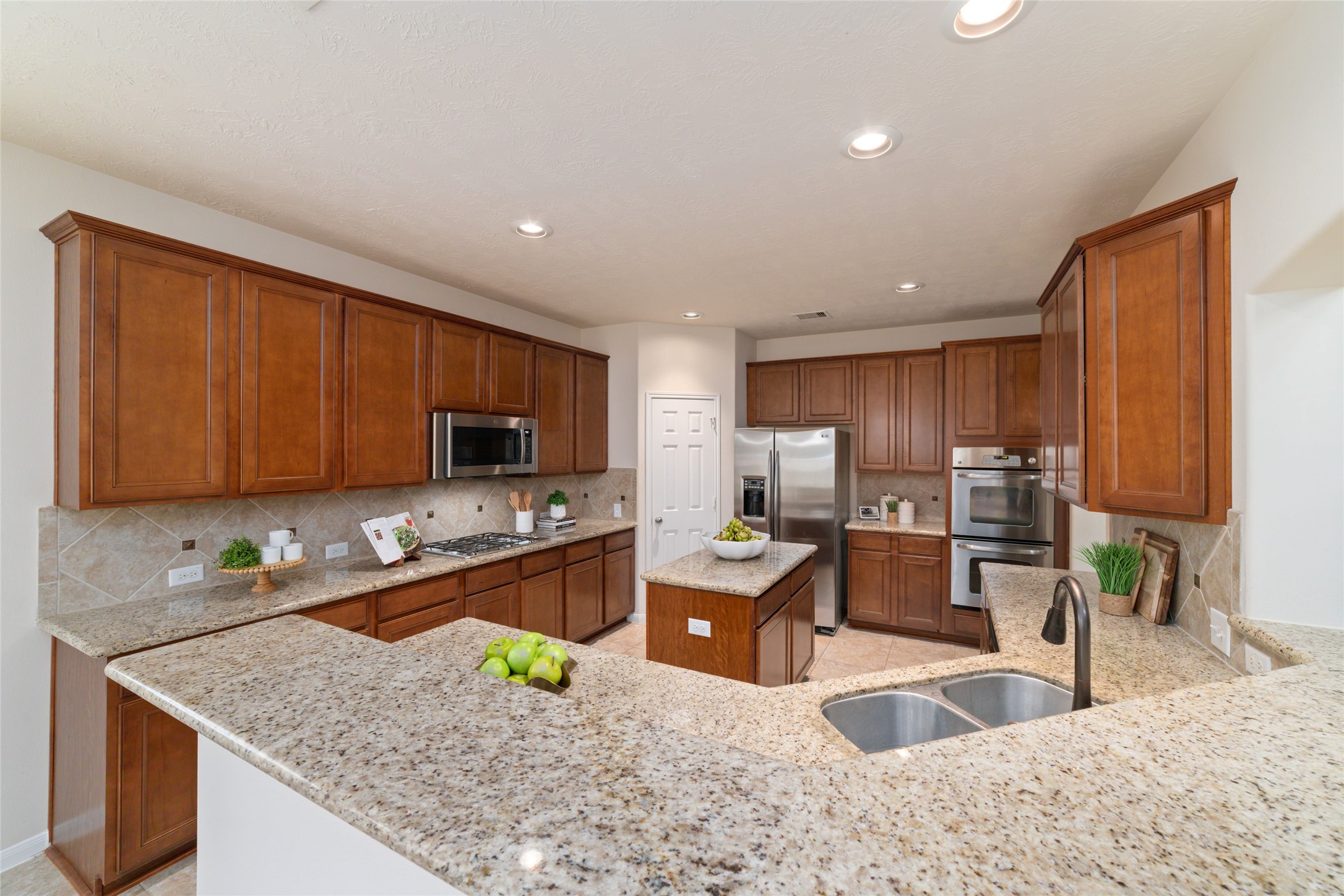 Expansive kitchen with breakfast bar, stainless steel appliances and double ovens perfect for everything from casual breakfasts to entertaining a crowd