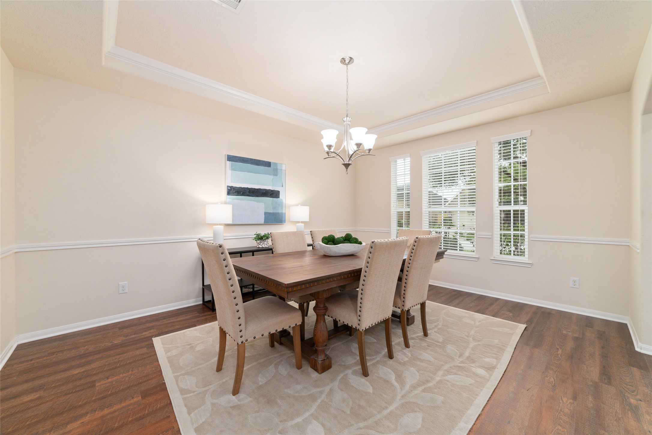 Formal dining room with tray ceiling, crown molding and plenty of natural light perfect for hosting dinners and making memories.