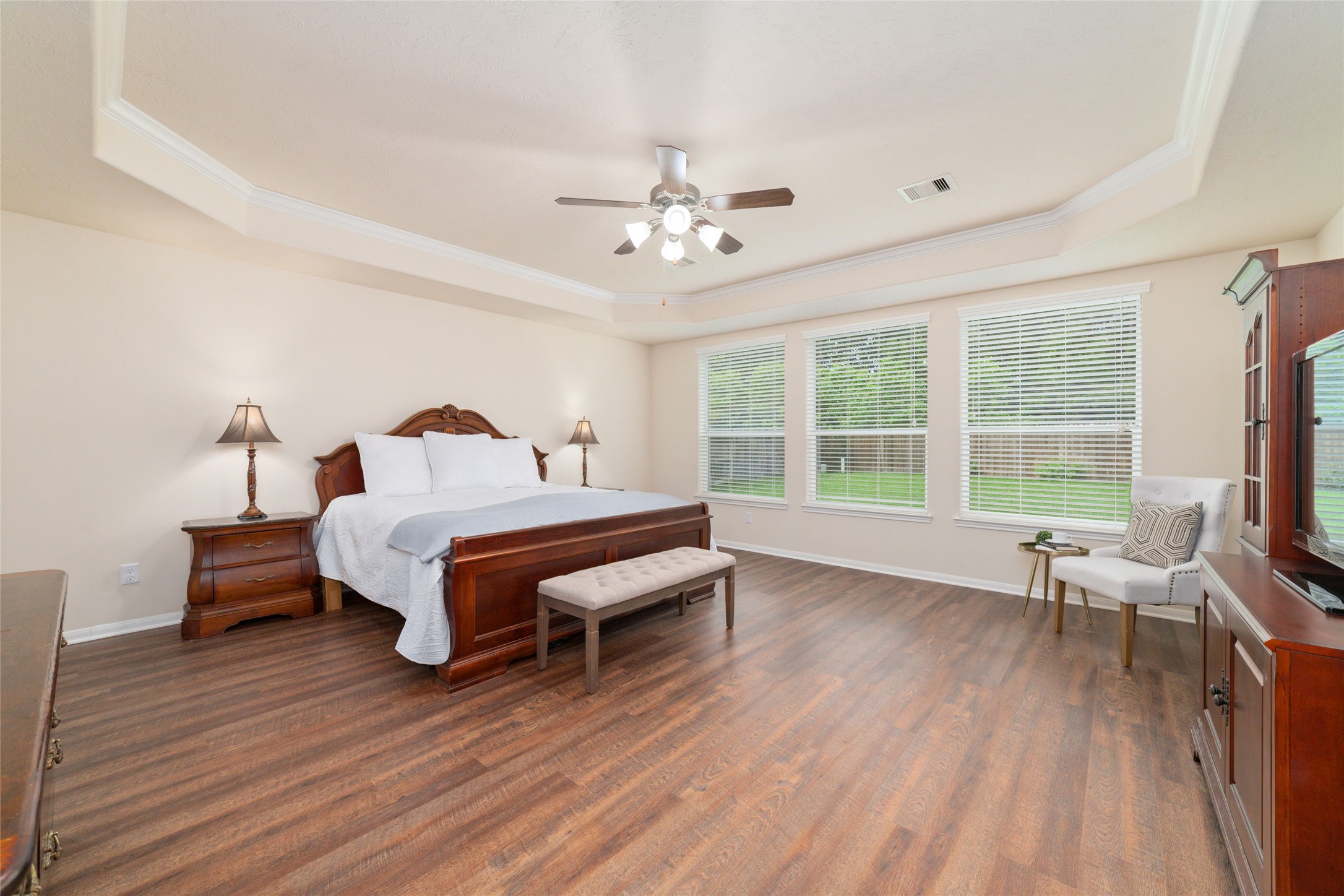 The huge primary suite with tray ceiling, new wood flooring and plenty of natural light create an inviting space to recharge and relax