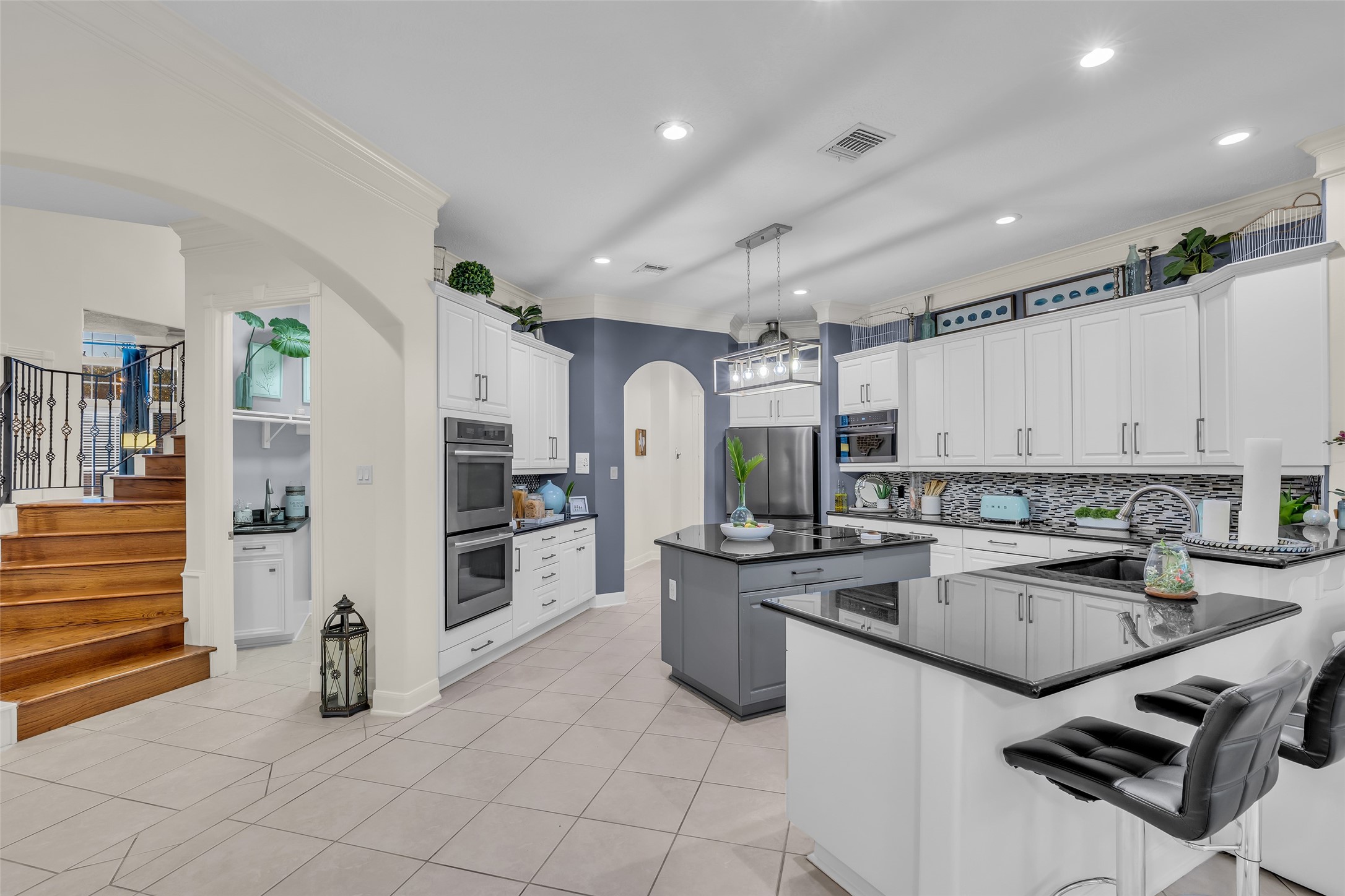 The kitchen has been updated with a contemporary backsplash, painted cabinets and appliances.