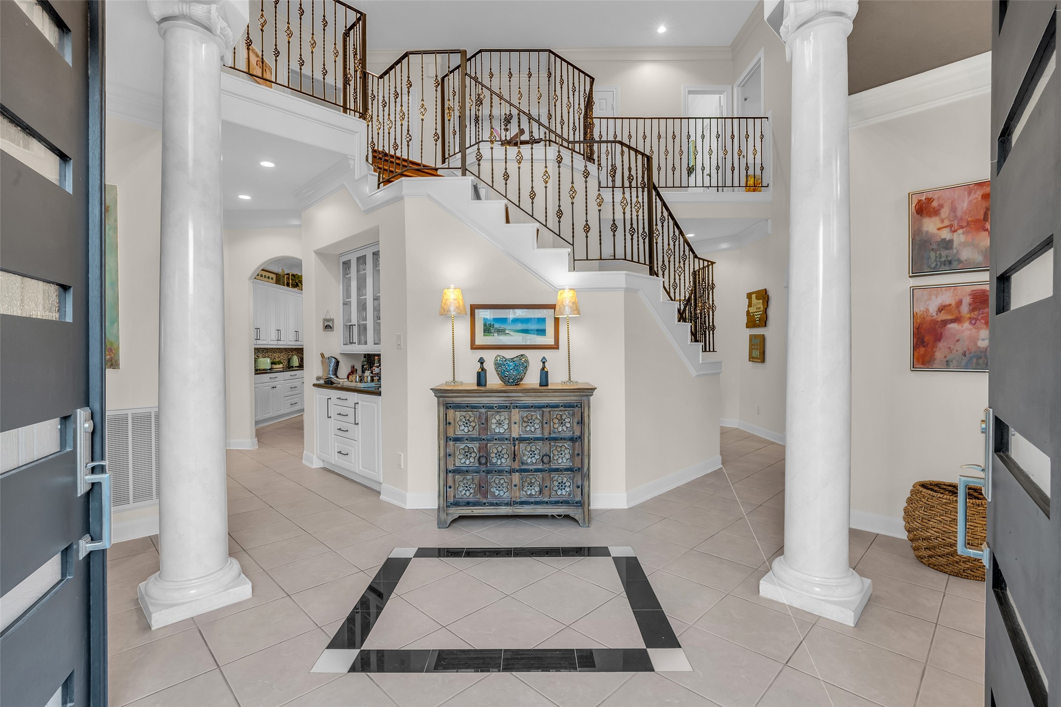 Elegant entry with grand staircase and wrought-iron railing.