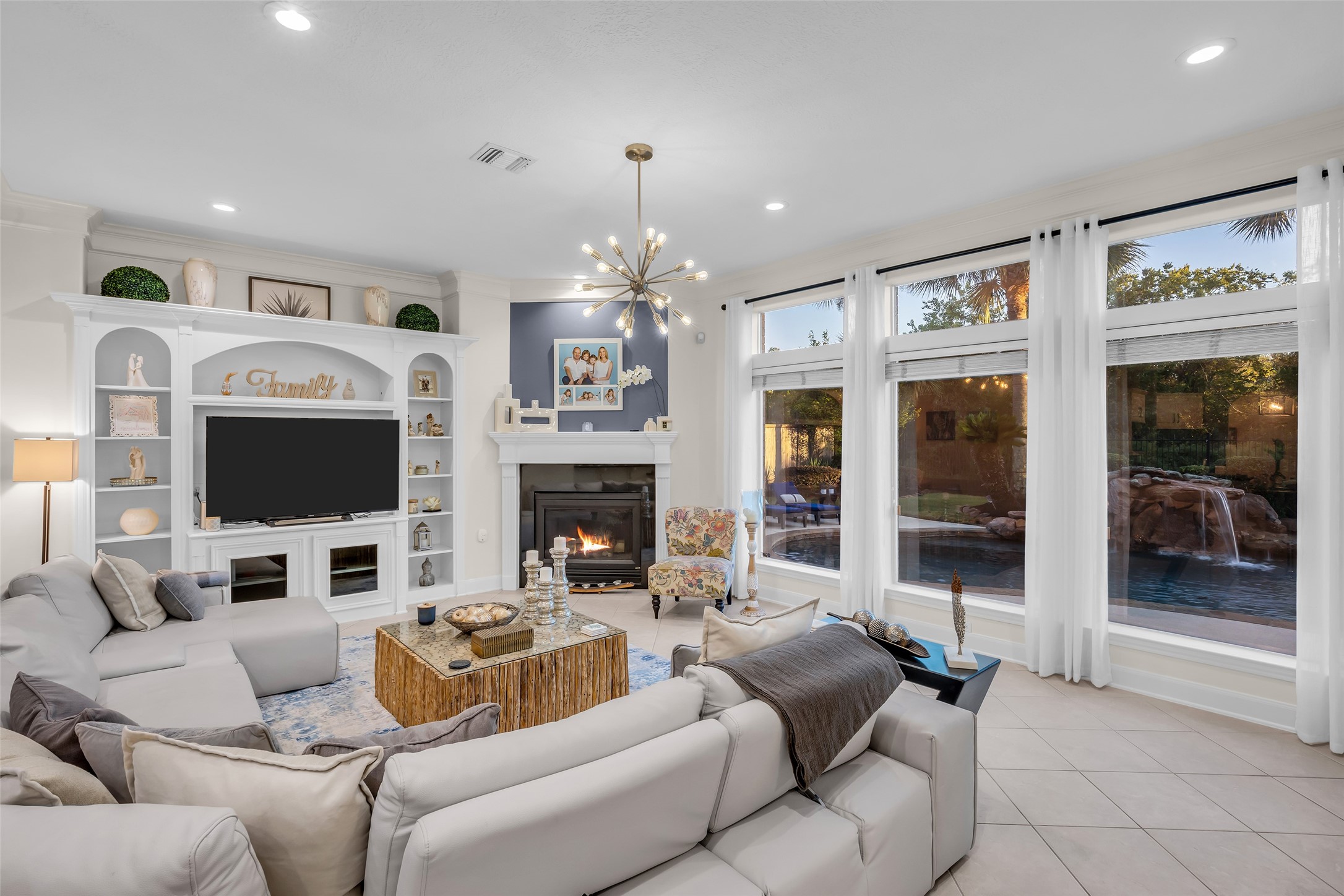 The living area with a wall of windows overlooks the backyard and provides an abundance of natural light.