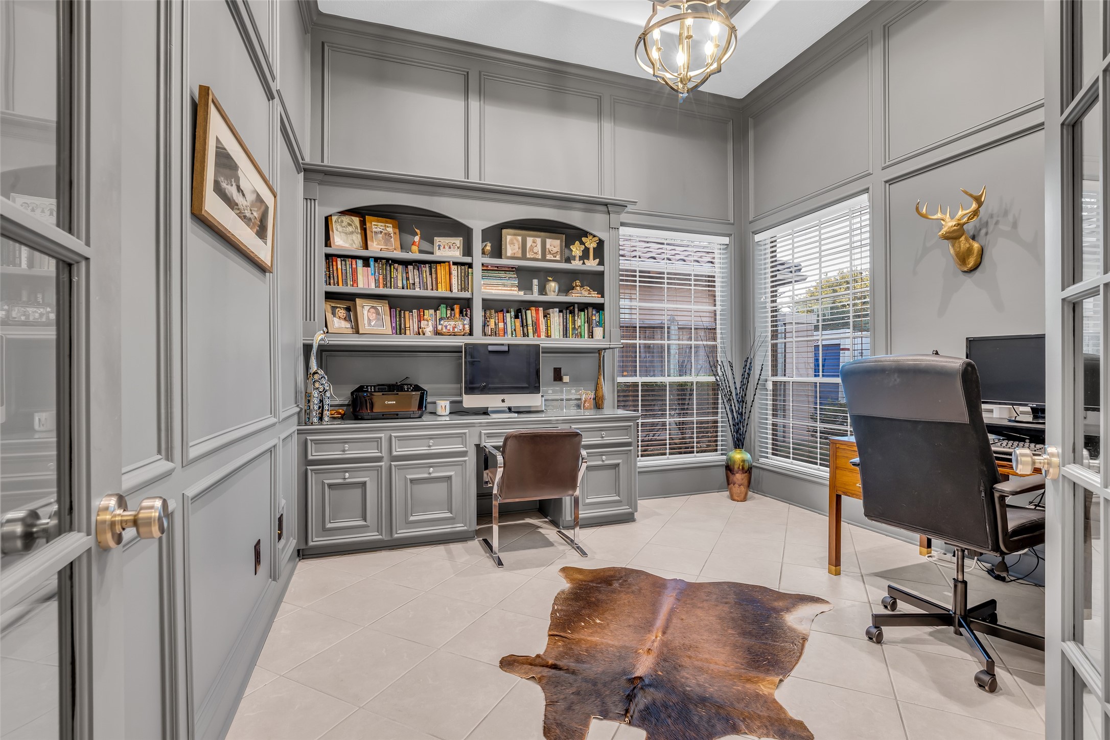The home office/study with wood paneling has French doors for extra privacy.