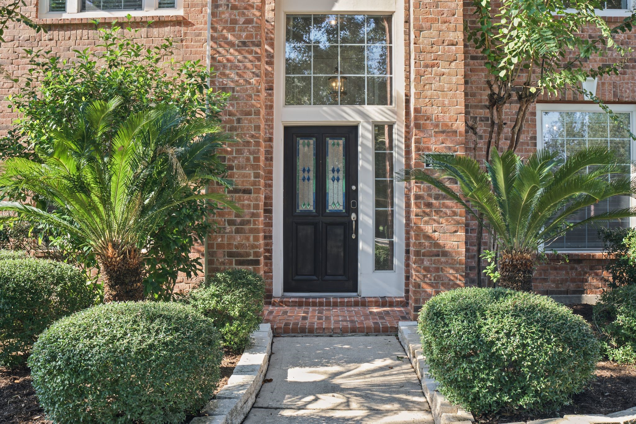 Approach the front entrance, where decorative glass, sidelights, and a tall overhead window offer a warm welcome. Approach the front entrance, where decorative glass, sidelights, and a tall overhead window offer a warm welcome.