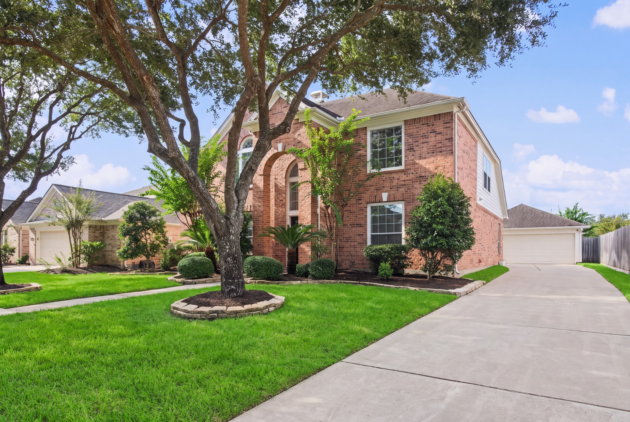 Along the side of the home, an extended driveway leads toward a 2-car detached garage, with a covered walkway to the home. Along the side of the home, an extended driveway leads toward a 2-car detached garage, with a covered walkway to the home.
