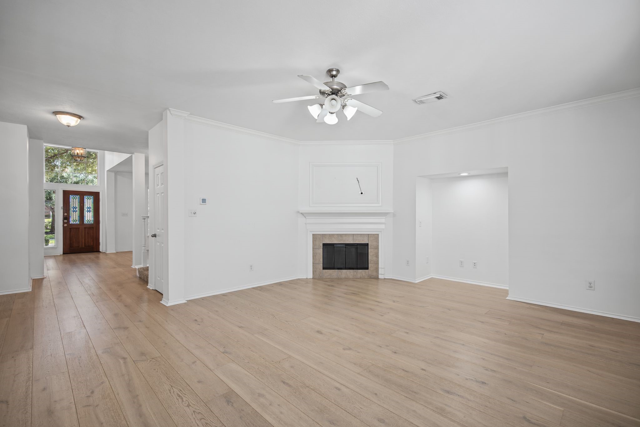 This perspective reveals the connection to the entry hall and the architectural recess beside the fireplace.