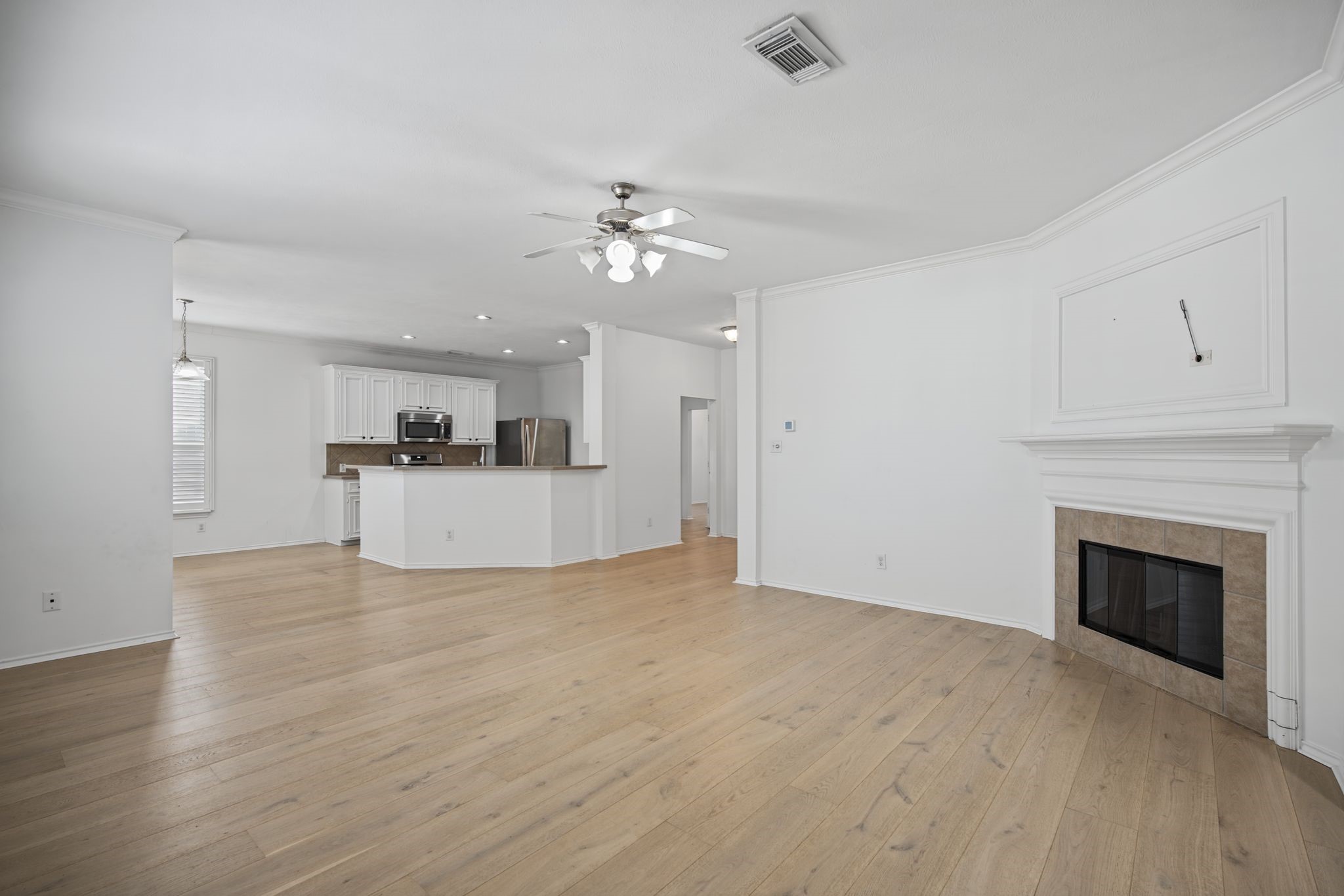 Looking toward the kitchen, the fireplace surround adds a focal point to the open living space.