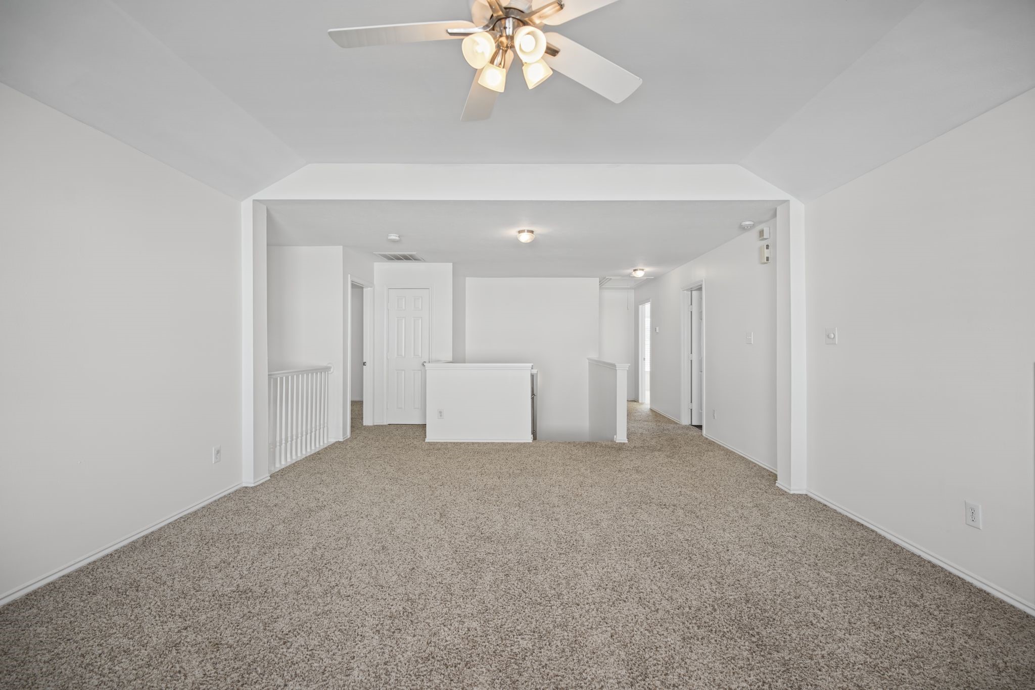 As you head upstairs, the spacious game room offers an inviting extension of the homes living areas, with carpeted flooring and an open connection to the stair landing.