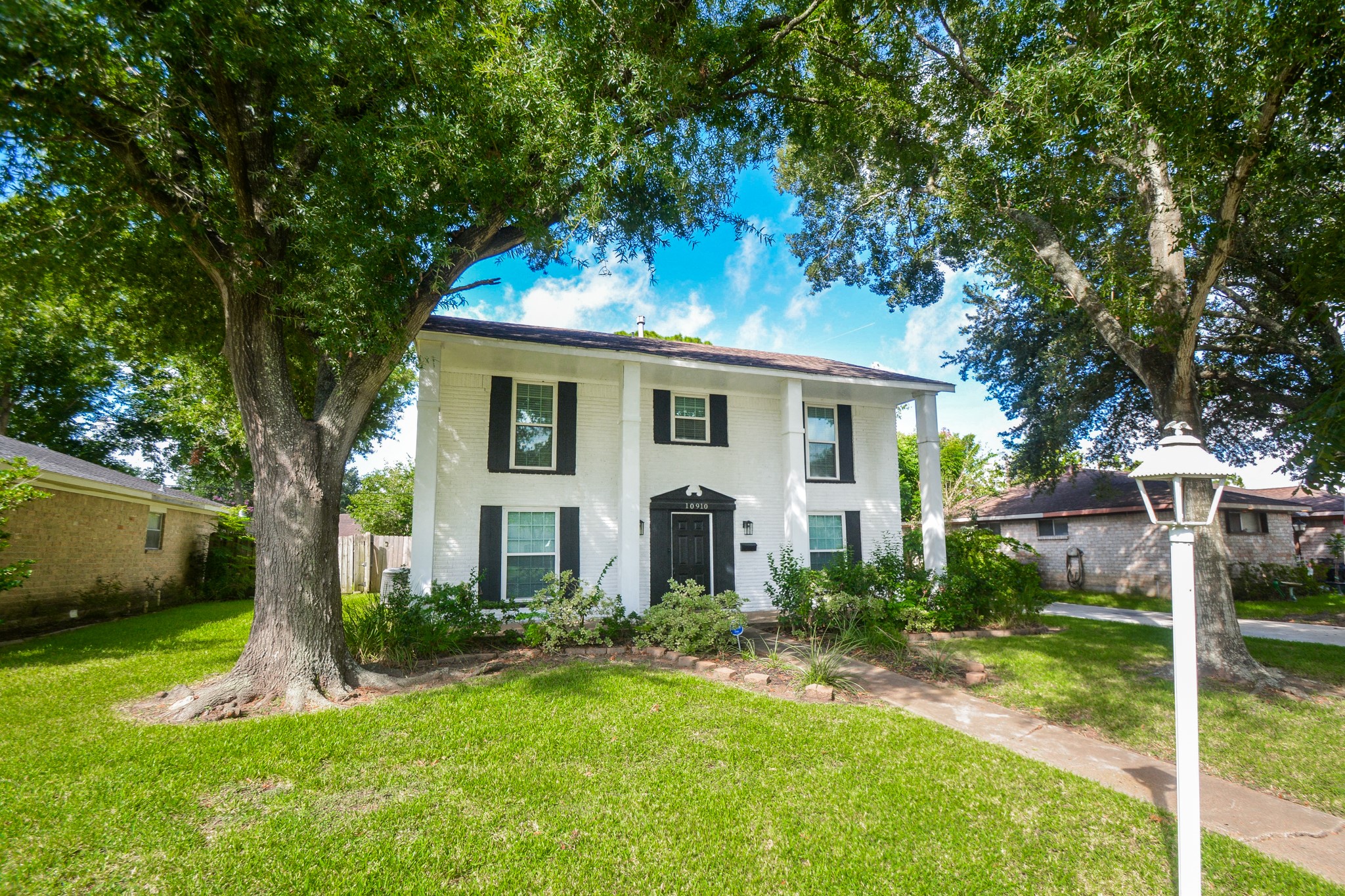 Grand view of the home with sprawling front lawn and trees for shade. Grand view of the home with sprawling front lawn and trees for shade.