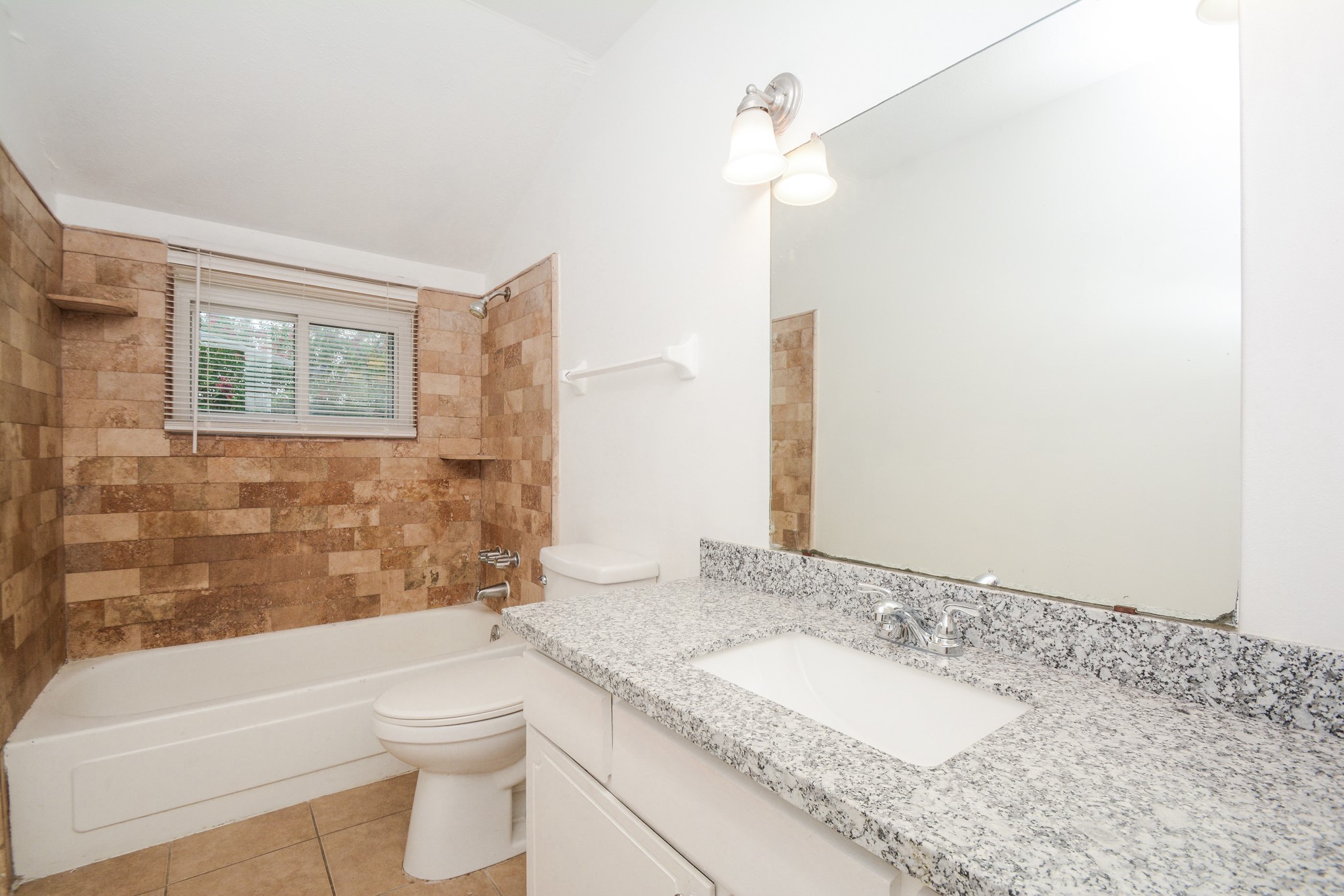 Designer tile bathtub with granite countertop.