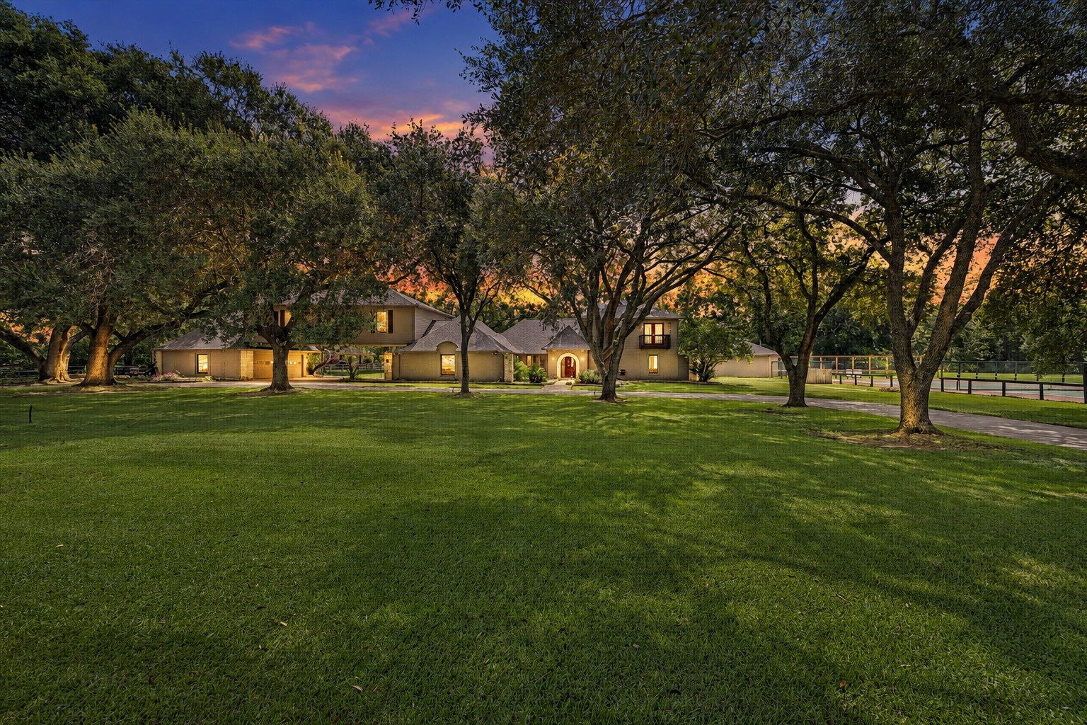 WIDE FRONT LAWN AND ESTABLISHED MATURE TREES CREATE A PRIVATE, PARK-LIKE SETTING AROUND THE HOME.
