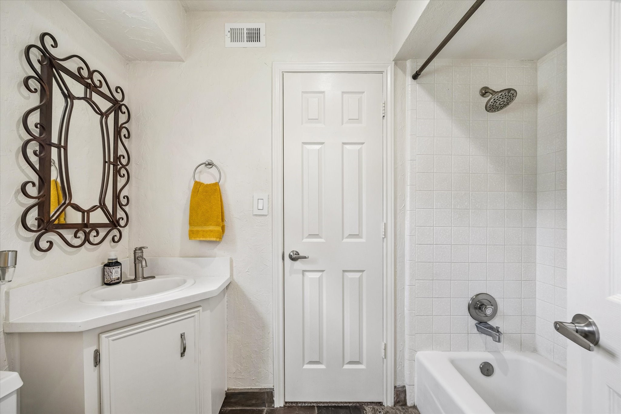 FULL BATH FEATURES A VANITY WITH STORAGE, TILED TUB/SHOWER SURROUND, AND NEUTRAL FINISHES.