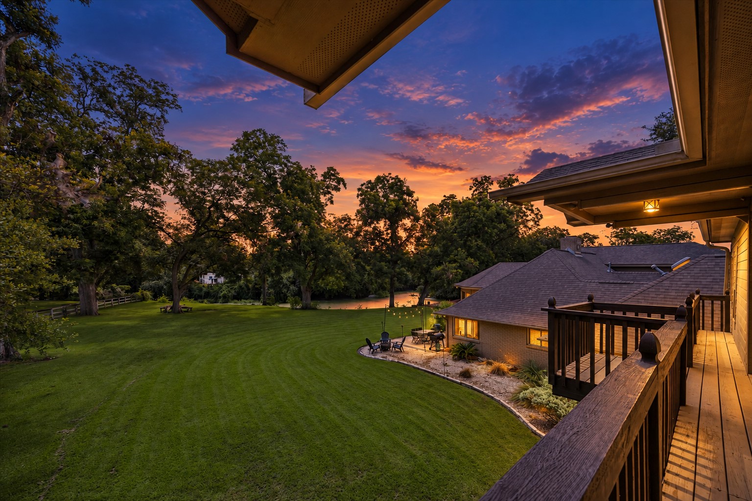 ELEVATED BALCONY OVERLOOKS THE EXPANSIVE BACKYARD, MATURE TREES, AND SURROUNDING GREEN SPACE.
