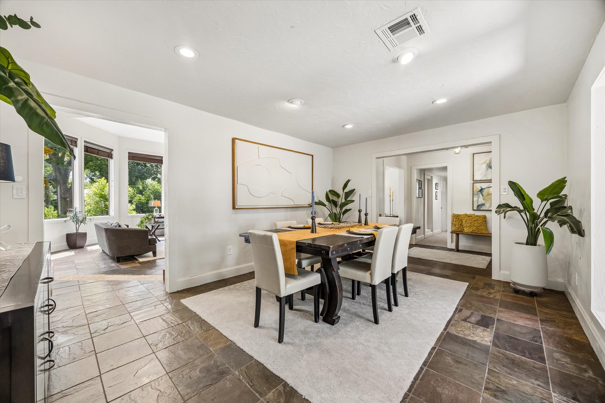 DINING SPACE FEATURES TILE FLOORING, RECESSED LIGHTING, AND WIDE OPENINGS THAT CONNECT TO ADJACENT LIVING AREAS.
