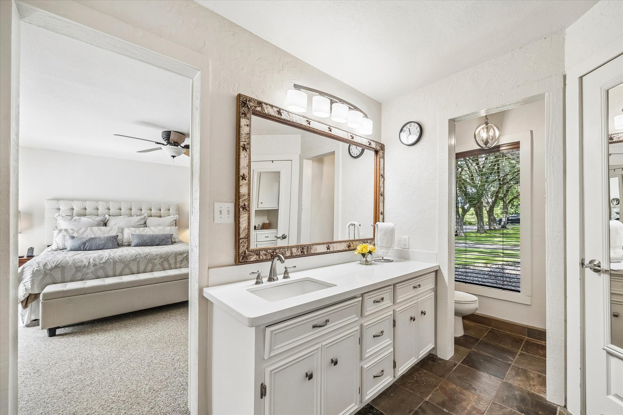 PRIMARY BATHROOM INCLUDES A LARGE VANITY, AMPLE CABINET STORAGE, TILE FLOORING, AND DIRECT ACCESS TO THE PRIMARY BEDROOM.