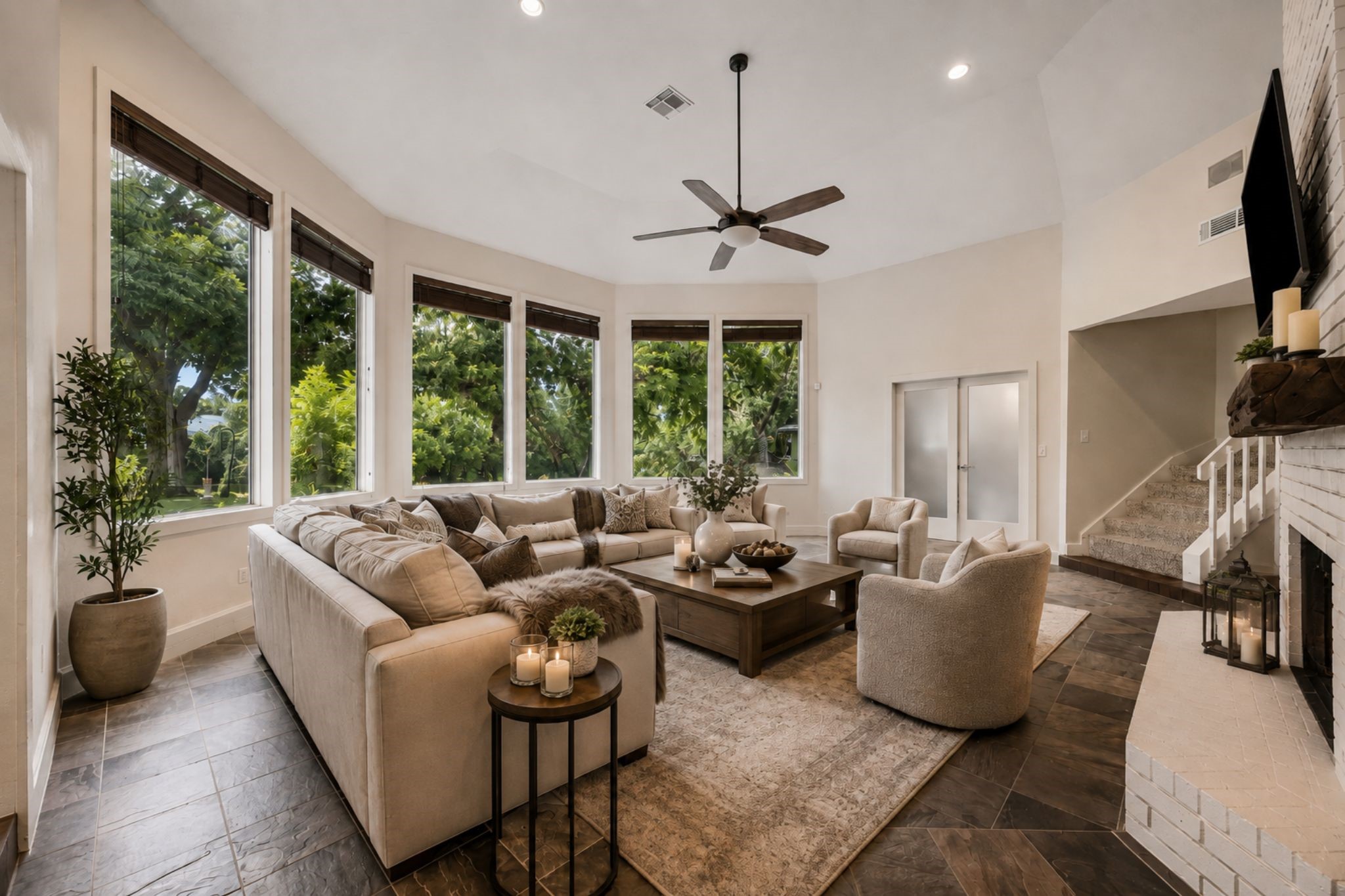 LARGE WINDOWS WRAP THE LIVING AREA, FILLING THE SPACE WITH NATURAL LIGHT AND PROVIDING VIEWS OF THE SURROUNDING GREENERY. ***Virtually Staged.