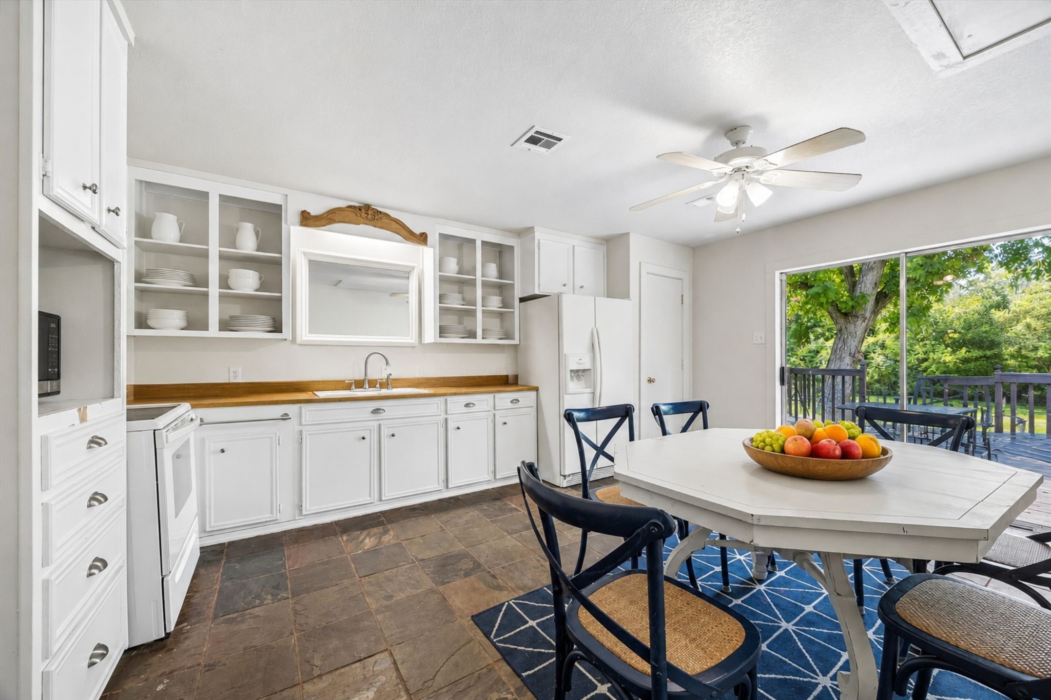 GUEST HOUSE FEATURES A FULL KITCHEN WITH BREAKFAST AREA - BUILT-IN CABINETRY, AMPLE STORAGE, TILE FLOORING, AND DIRECT ACCESS TO THE OUTDOOR PATIO.