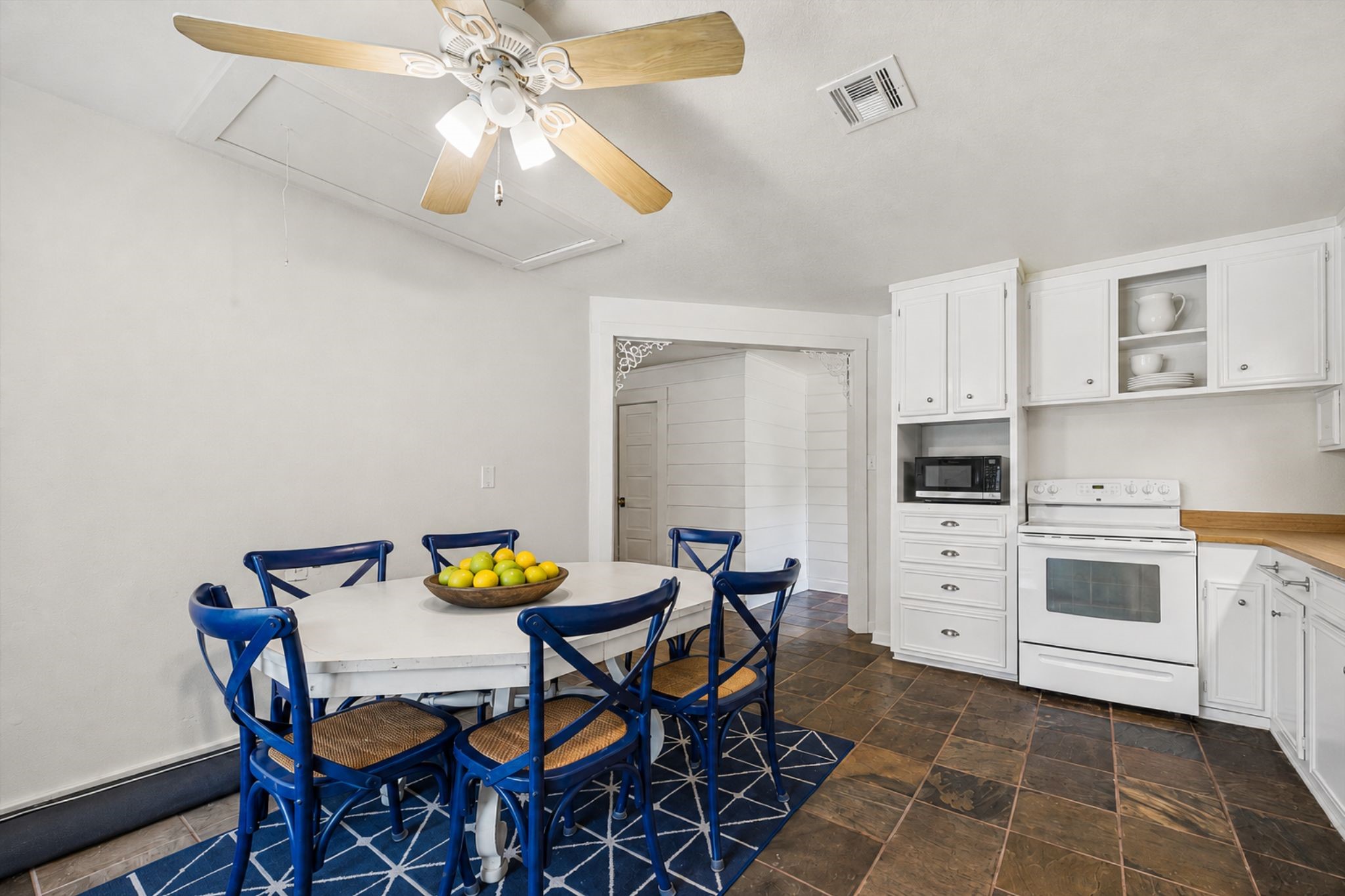 OPEN BREAKFAST AREA CONNECTS DIRECTLY TO THE KITCHEN AND OFFERS BUILT-IN STORAGE, TILE FLOORING, AND A CEILING FAN.