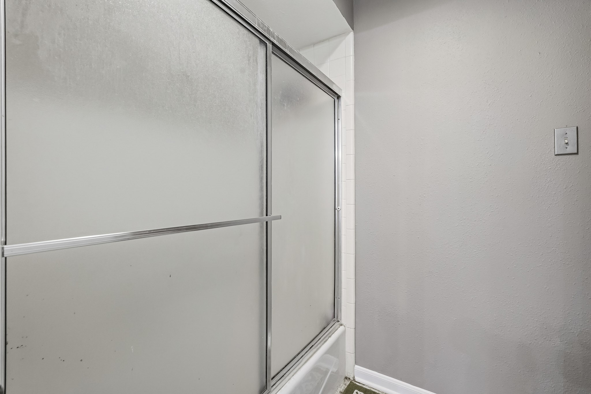 Glass-enclosed shower with a clean, neutral color palette for a fresh and inviting atmosphere.