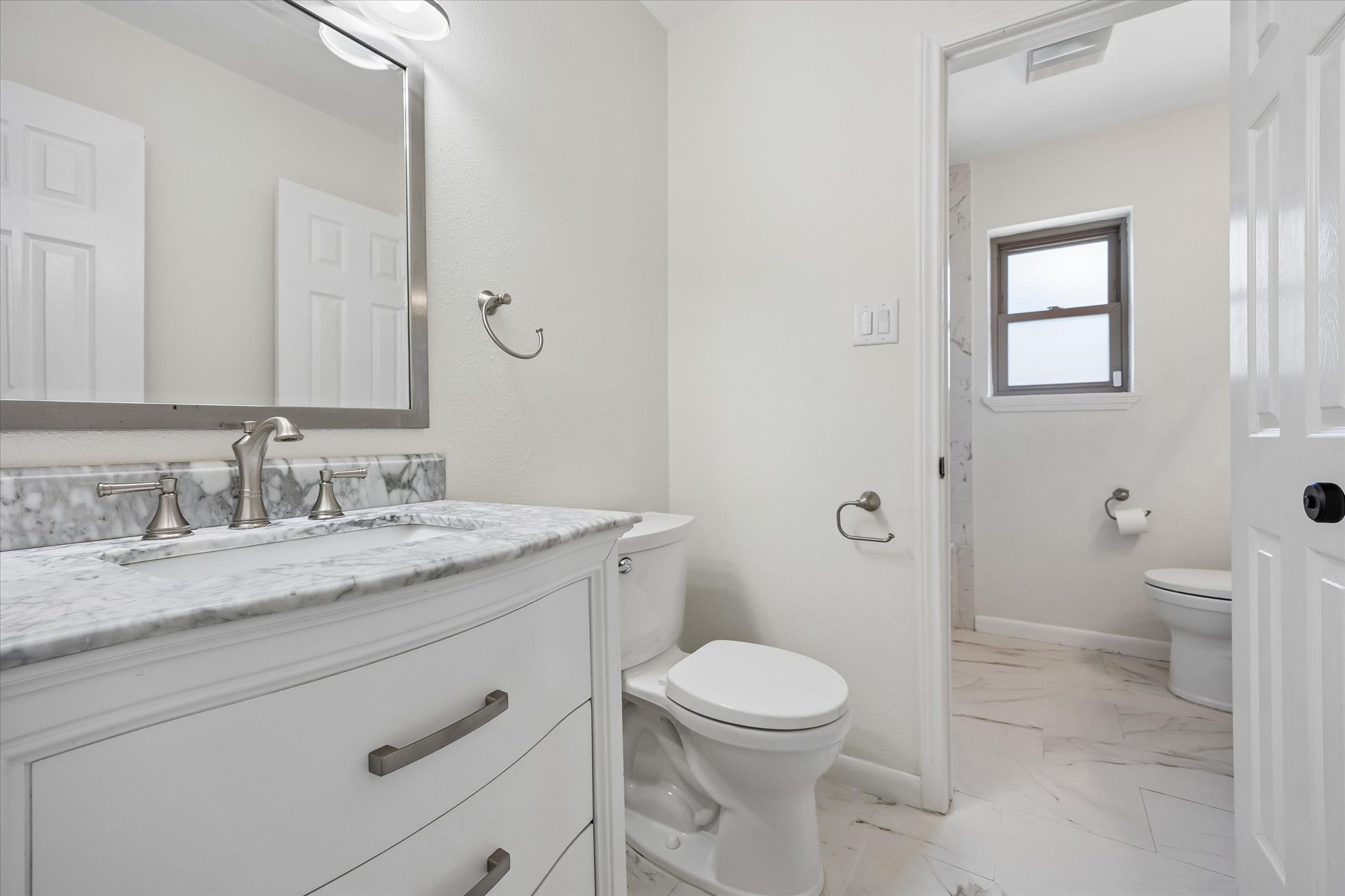 Beautifully updated guest bath offers separate sink areas and tub/shower combo with subway tile surround.