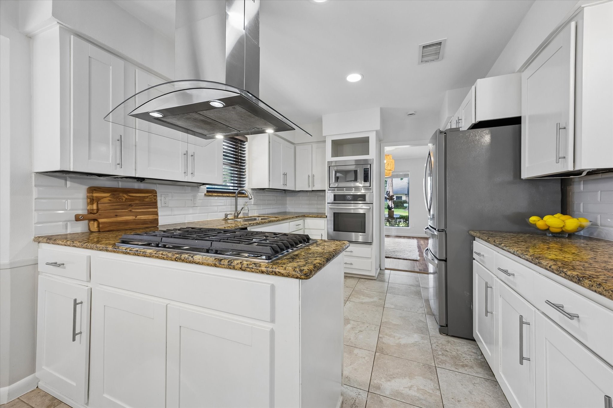 Another perspective of the kitchen showing the abundant storage and prep space.