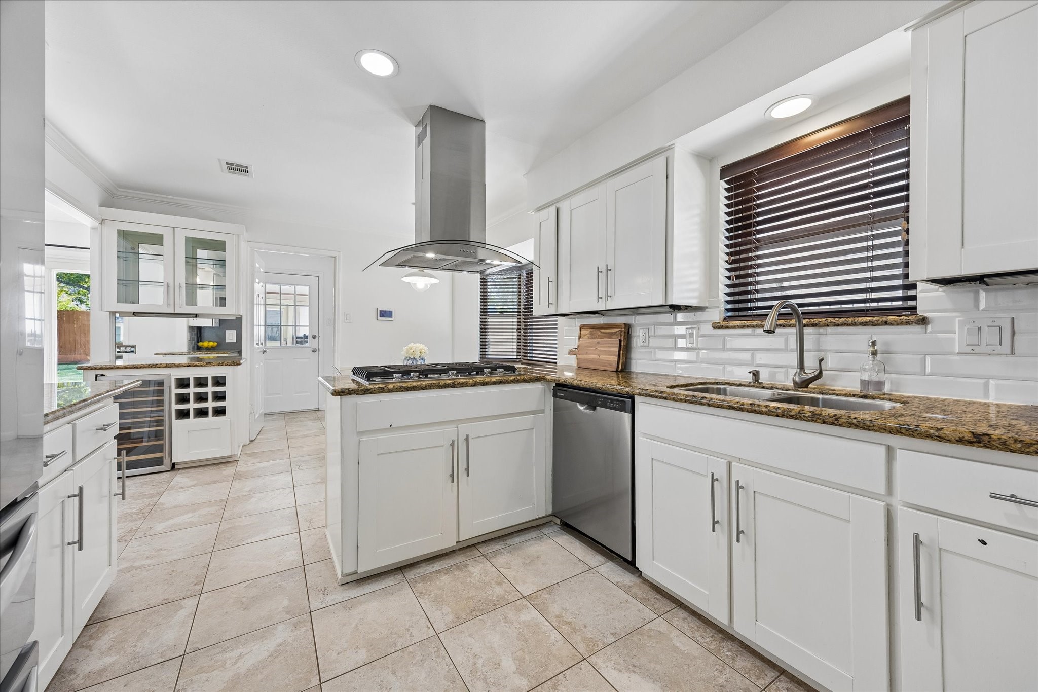 Kitchen is equipped with stainless steel appliances including Kitchenaid gas stove top and Jenn-Air convection oven.