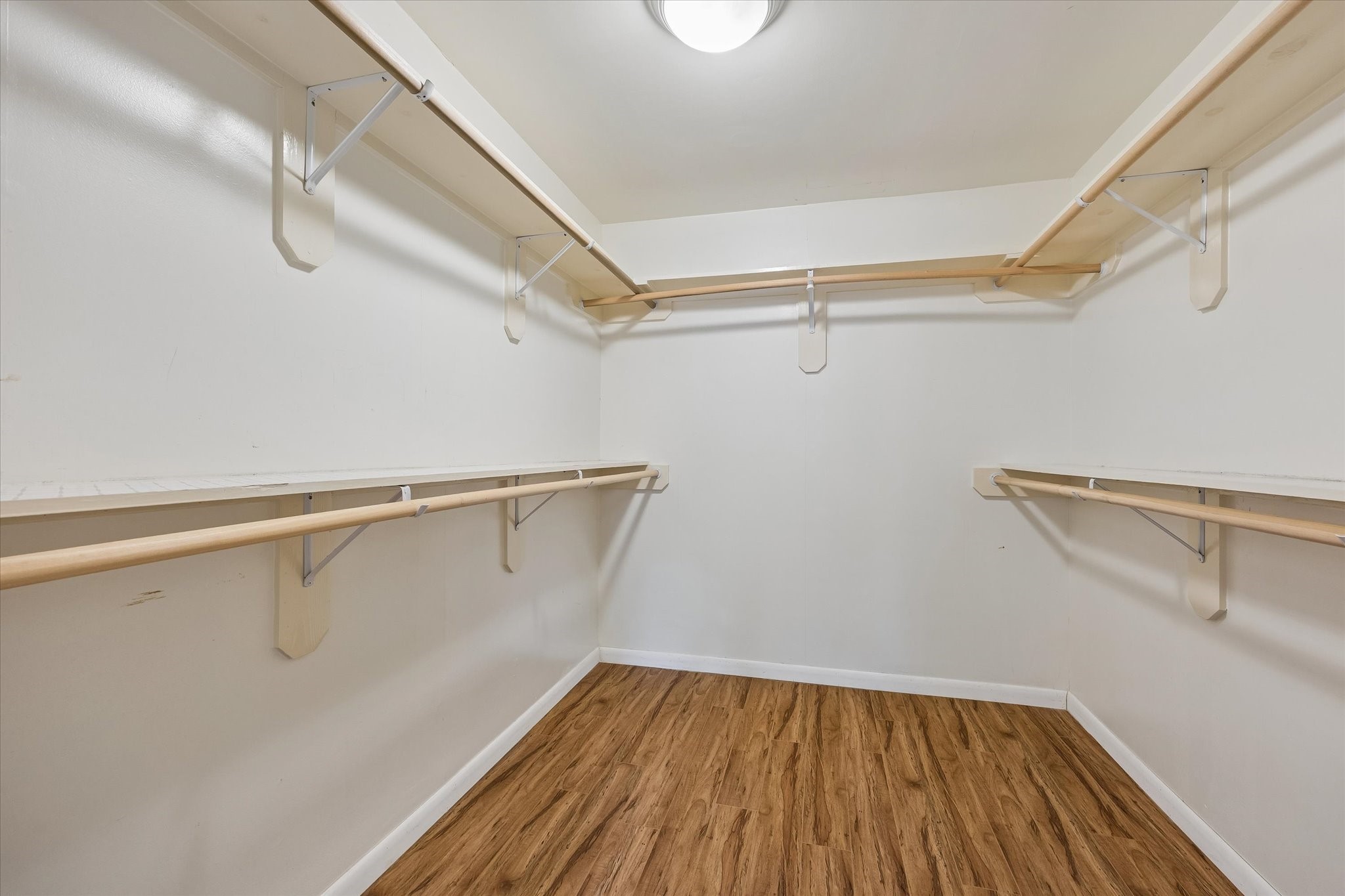Primary walk-in closet features an impressive amount of hanging space.