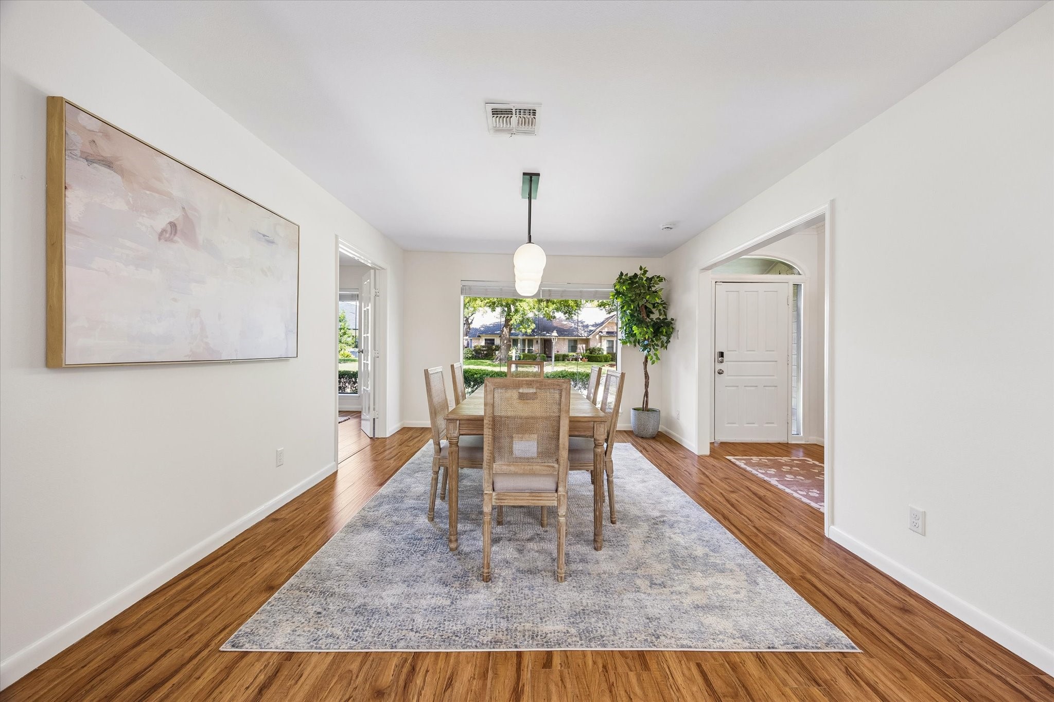 The sun-filled formal dining room features windows that frame gorgeous views of the front yard. Throughout the entire home, youll find the added convenience of custom-fit blinds for light control and privacy.