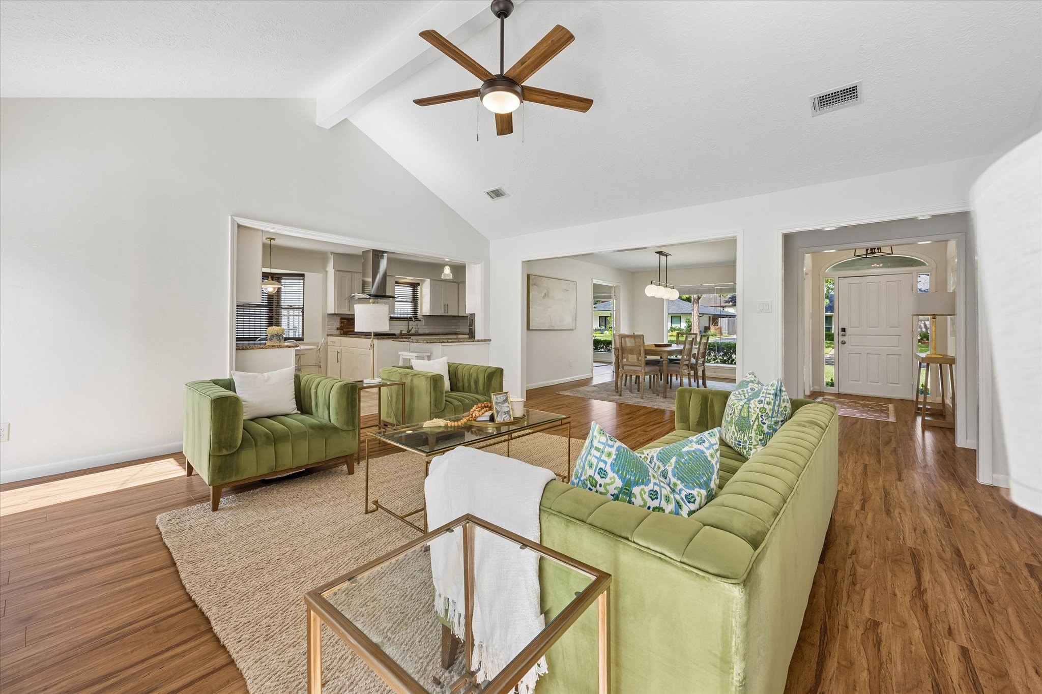 This perspective highlights the homes effortless layout, where the expansive main living area transitions beautifully into the kitchen, breakfast room, and formal dining space.