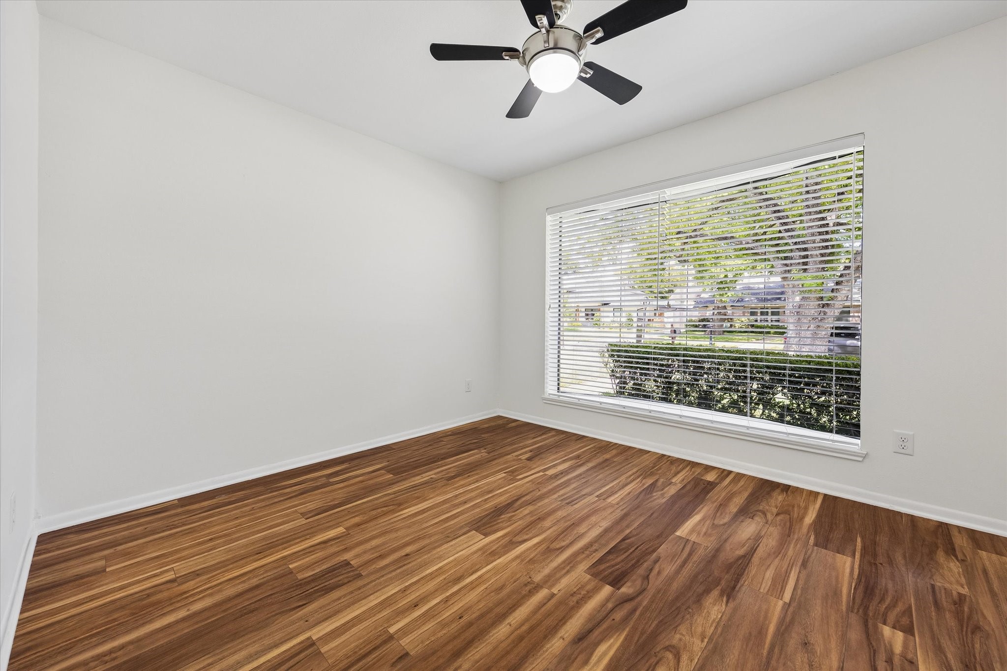 Another spacious guest bedroom at the front of the home featuring stunning views of the well manicured front yard.