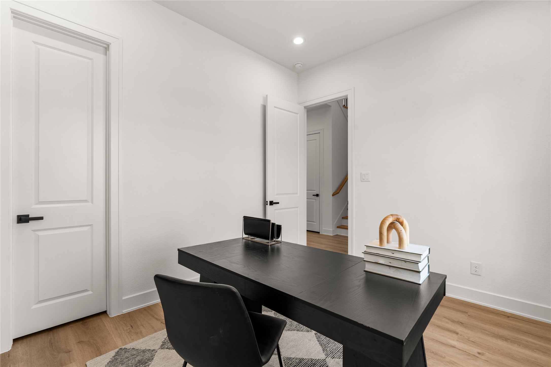 A closer look at the study reveals classic paneled doors, contrasting matte black hardware, and a restrained interior palette.