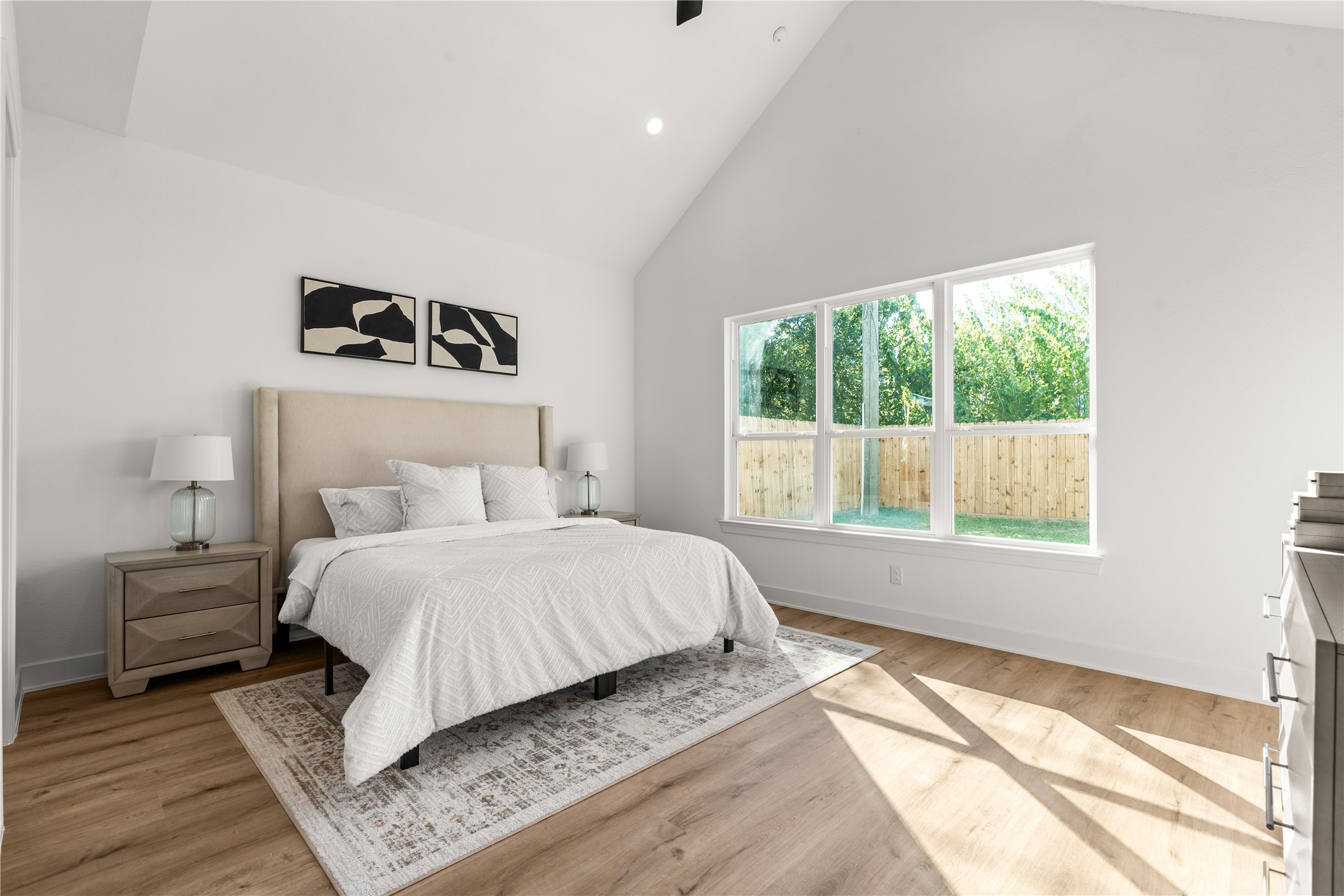 A trio of oversized windows frames views of the private backyard, lending the space an airy quality while maintaining a sense of intimacy.