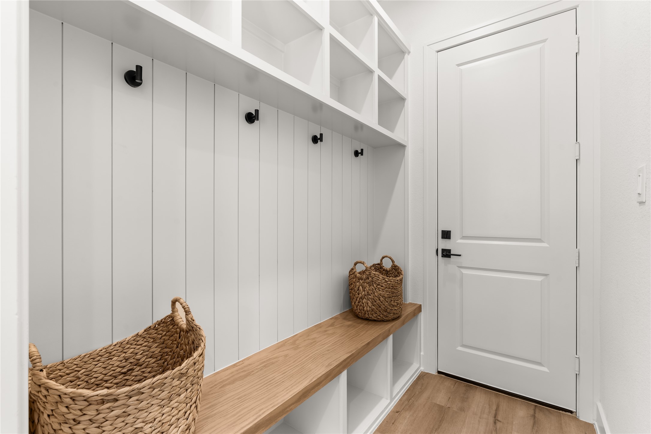 An often-overlooked space becomes an exercise in thoughtful design, where integrated storage and a streamlined bench create a convenient landing place upon arriving home.