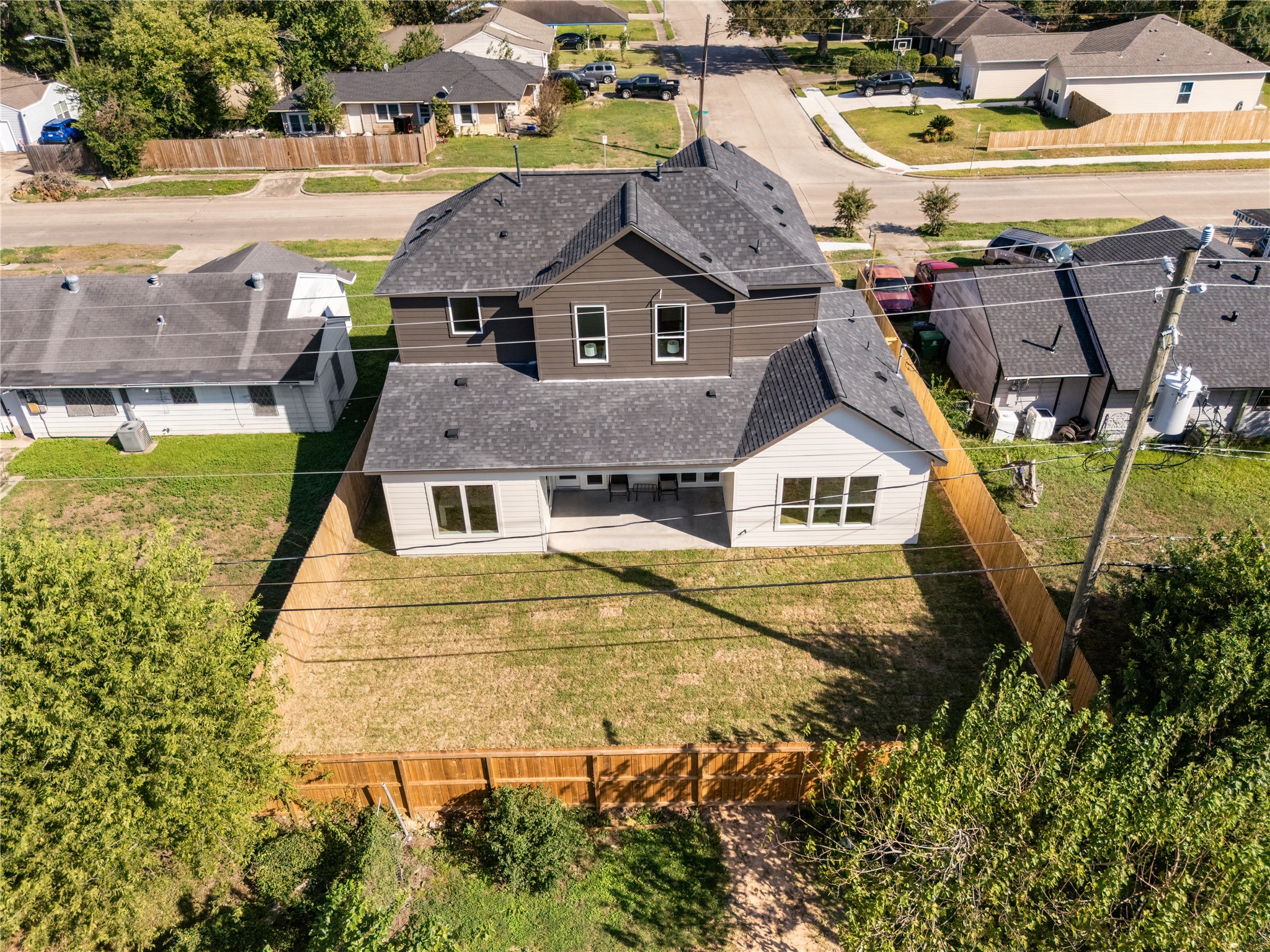 An elevated perspective showcases the home's generous backyard, complete with a covered patio and fully fenced lawn.