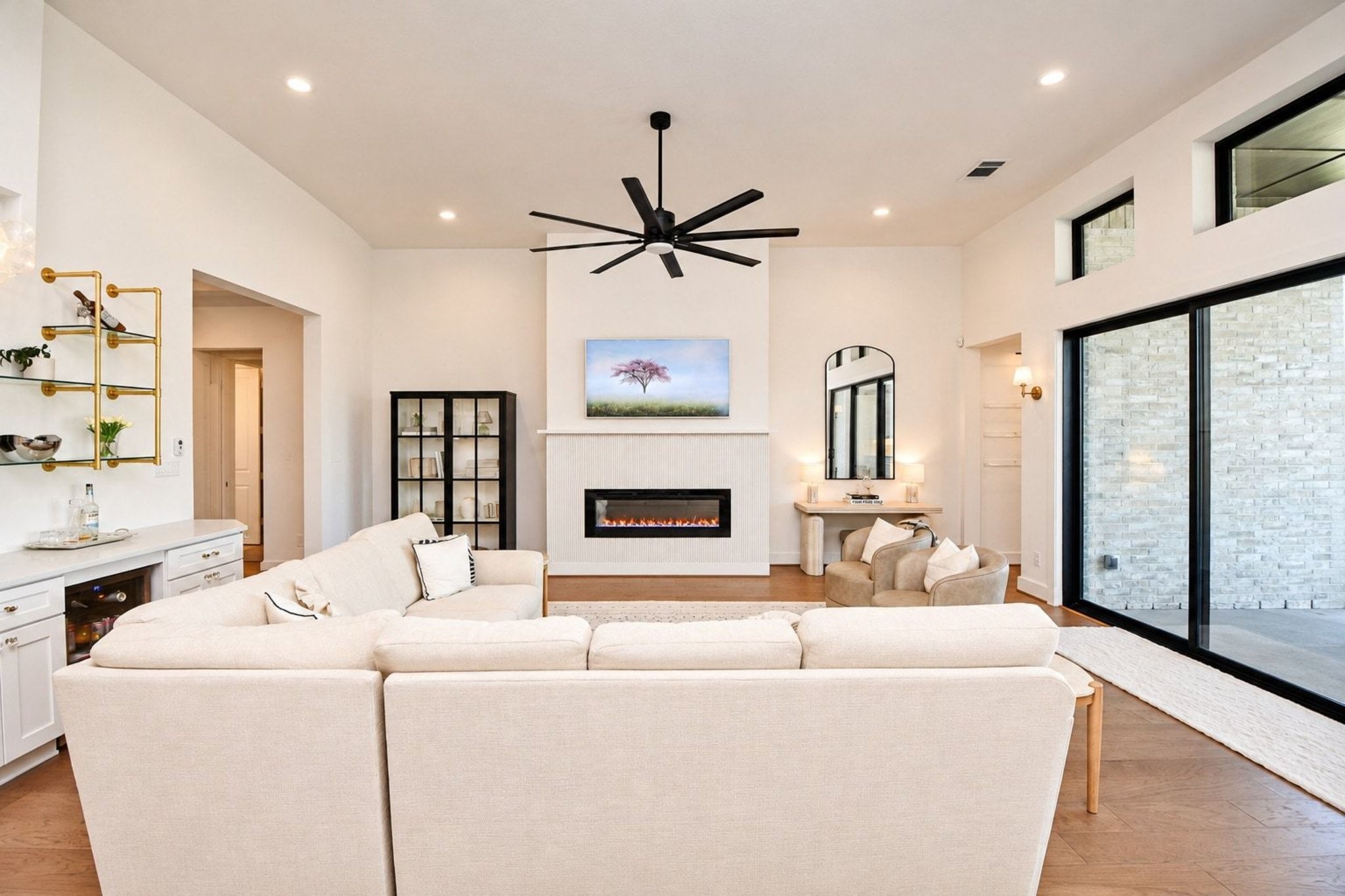 Spacious living room with high ceilings, featuring large sliding glass doors that flood the space with natural light.