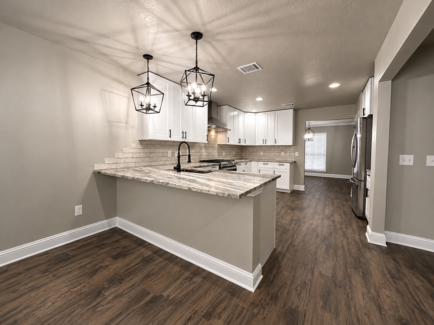 Open kitchen and breakfast area featuring a spacious breakfast bar with seating, perfect for casual dining and entertaining.