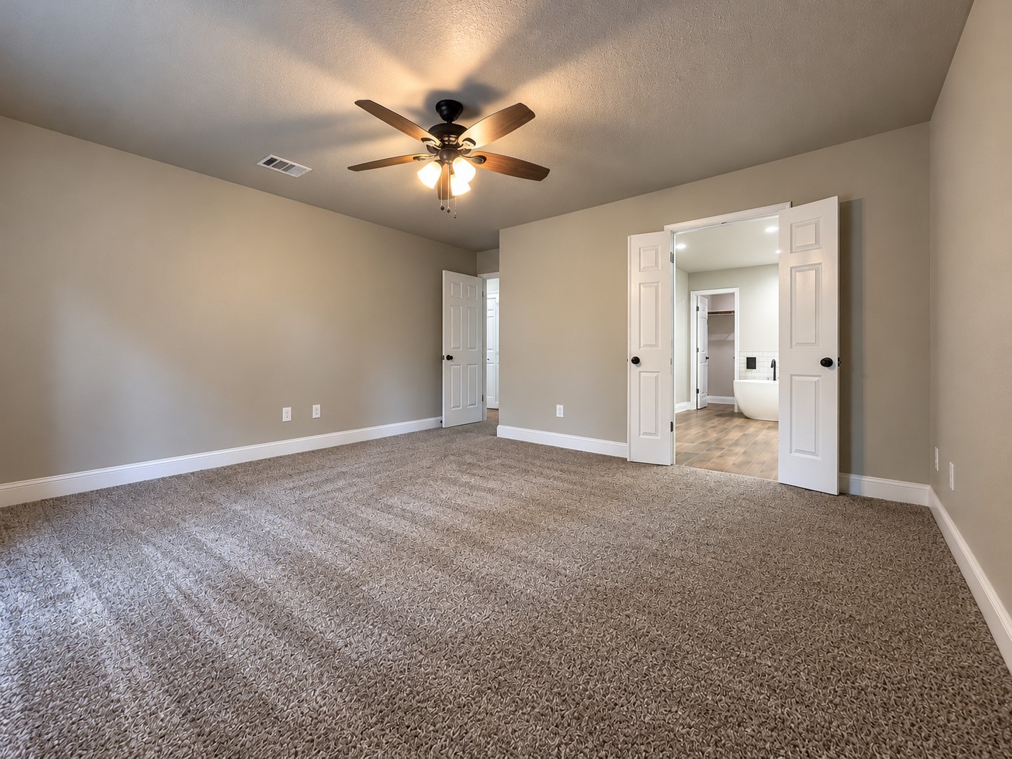 Spacious primary bedroom with a private en-suite bathroom featuring a freestanding soaking tub and beautifully updated finishes.